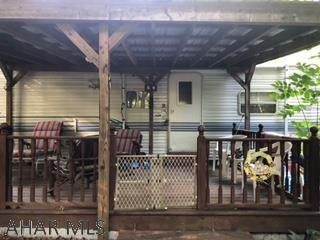 30 feet Nomad camper, land included, with covered deck.  Has a covered bridge with stream.  Has all amenities of Glendale Yearound.  Needs some TLC
