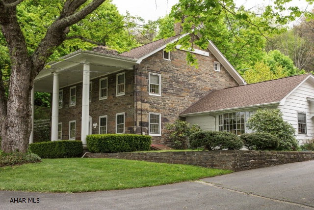 Take a step back in time with this stately Federal-style stone home with 4 bedrooms and 2.75 baths. Built in 1843, the sign on the house front says Weaverly House and formerly served as a stage coach stop and Colonial style inn.  This property is truly unique since it sits on over 10 acres and includes a barn built in 1963 that was turned into a gift shop in 1988 and a full 2 bedroom guest apartment with large rooms built over a garage with multiple rooms and a workshop in 1940 which can also be rented for extra income.  Outdoor entertaining area behind house features an in-ground swimming pool and cabana along with closed-in porch and patio.  Watch the wildlife in your back yard descend from the mountain, feeling safe in the serenity and security of this 2-foot-thick walled homestead.