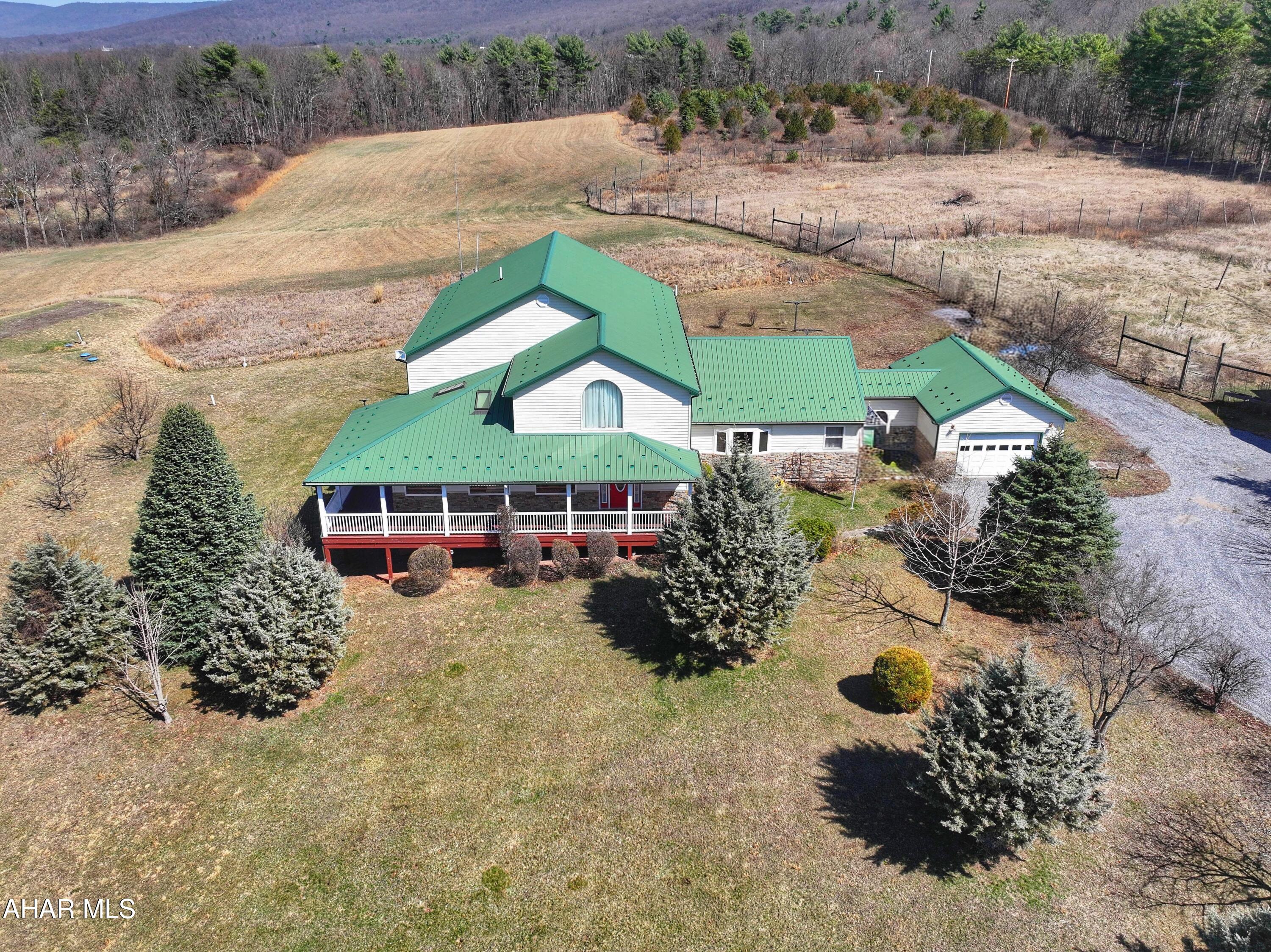 Situated on 115.2 acres, this one-of-a-kind property offers a wonderful combination of approximately 45 acres of open fields with the balance in woods and pasture, creating a versatile setting for recreation, farming, hunting, or simply enjoying unparalleled privacy and wide open space. Expansive afternoon views stretch across the countryside, providing a stunning backdrop for outdoor living and relaxation. This 4 bedroom, 3.5 bath custom built modern home spans 5,208 square feet and features a thoughtfully designed open floor plan ideal for both everyday living and entertaining. A soaring two story vaulted great room serves as the centerpiece of the home, seamlessly connecting to the kitchen and dining areas on the east side, while the bedrooms, office, and sunroom occupy the west side. All bedrooms are generously proportioned, offering comfort and flexibility for any lifestyle. Designed with energy efficiency and self-sufficiency in mind, the home is capable of full off grid living, equipped with a 44-panel solar array, battery backup, and LP generator. It also offers geothermal heating and cooling alongside a conventional HVAC system, and multiple wells provide added versatility for residential or agricultural use. A main floor laundry and a full bath adjacent to the attached one car garage enhance convenience for everyday life. In addition to the garage, the property includes an expansive 66' by 40' pole building, complete with tools and equipment, making this estate truly move in ready. With its exceptional combination of modern amenities, sustainable systems, and breathtaking land, this property represents a rare opportunity so give us a call today to make it your next home!