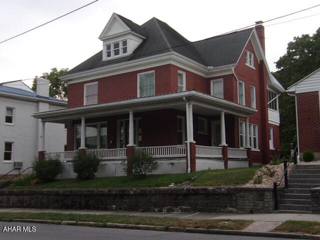 Lovely 2 story brick home, features high ceilings throughout, even the basement.  The spacious foyer opens up onto a large dining room and even larger living room with separate reading/sitting area.  Original woodwork, crown molding, wainscotting, pocket doors, and 2 staircases.  Wonderful patterned hardwood floors.  Lots of cupboards and workspace in this kitchen with appliances.  Main level laundry area with easy access to open, level back yard.  The main front staircase opens onto a large, open, light filled bonus area.  Next are 3 large bedrooms and full bath.  The hallway ends at an upper covered porch, a second set of stairs, and the entrance to an immense, open, unfinished attic.  The walkup attic is floored, and has windows on all 4 sides.  This space could be finished to expand the living area to 3 floors.  Wrap around front porch and 2nd story covered porch in back.  Off street parking and a 1 car garage is located at the rear of the property on the alley.  Restore this beauty to her former glory and make this home your own!