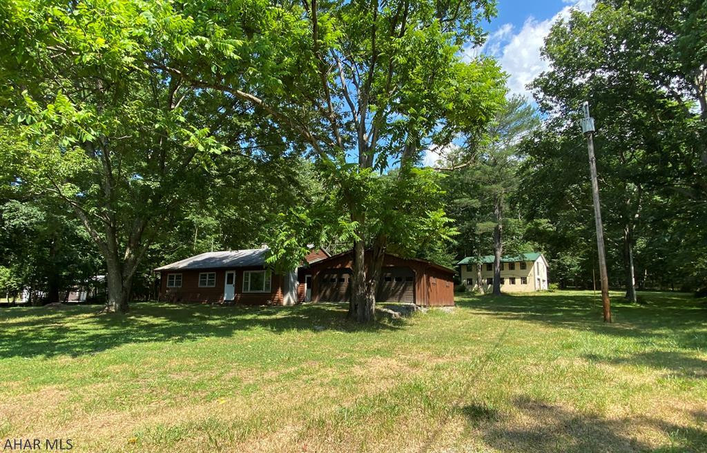 This hidden gem offers so much!  This 2 bedroom 2 bath rancher sits on almost an acre lot nestled in a beautiful quiet setting.  With a little TLC this could be someone's dream cottage or even a hunter's cabin with the state game land near by.  The newly insulated attached 2 car garage and breezeway provide a great addition to this home.  Also included is a large 2 story concrete block building housing a 2 car garage and could be renovated for a mother-in-law suite or guest retreat.  So many possibilities makes this home one that won't last long.