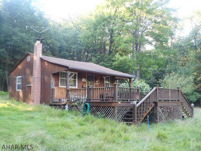 Great get-away! 10.3 acres with about 3 ac cleared and the balance woods - 2 bedroom camp with kitchen/living room and propane heater.3/4 bath with compost toilet - no septic. Newer 1.5 car detached garage. Covered picnic pavilion with fireplace.  Pond for fishing or swimming.  Call for additional details.