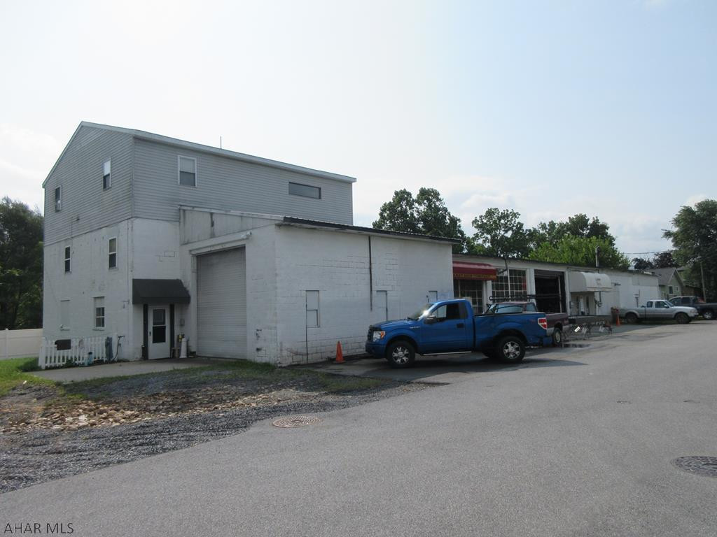 Commercial property in Hollidaysburg on 1 acre! Concrete block shop area with overhead doors and adjoining office area. Main shop ceilings approx 11', main overhead doors approx 10'6", left side overhead door approx 12'.  2nd floor residential apartment. Real estate only - business not being sold. Property needs work, but great opportunity for the right buyer. AS-IS sale. Seller will make no repairs.