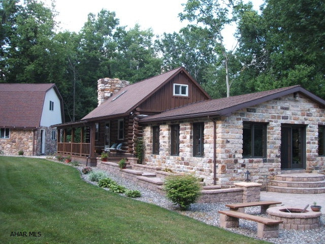 WOW! Breathtaking Property.  Log and stone home on 2.7 private acres.  Spectacular Views.  Close to hunting and fishing.  Minutes from Raystown Lake. Gorgeous stone patio for entertaining. Trickling waterfall. Amazing landscaping surrounds the entire home.  Sit in the hot tub on back deck and watch the wildlife.  2 car detached stone garage with finished 2nd floor. Finished basement with wet bar (more entertaining!) Great Room with vaulted ceilings and year round panoramic views.  Stone fireplace in Living Room.