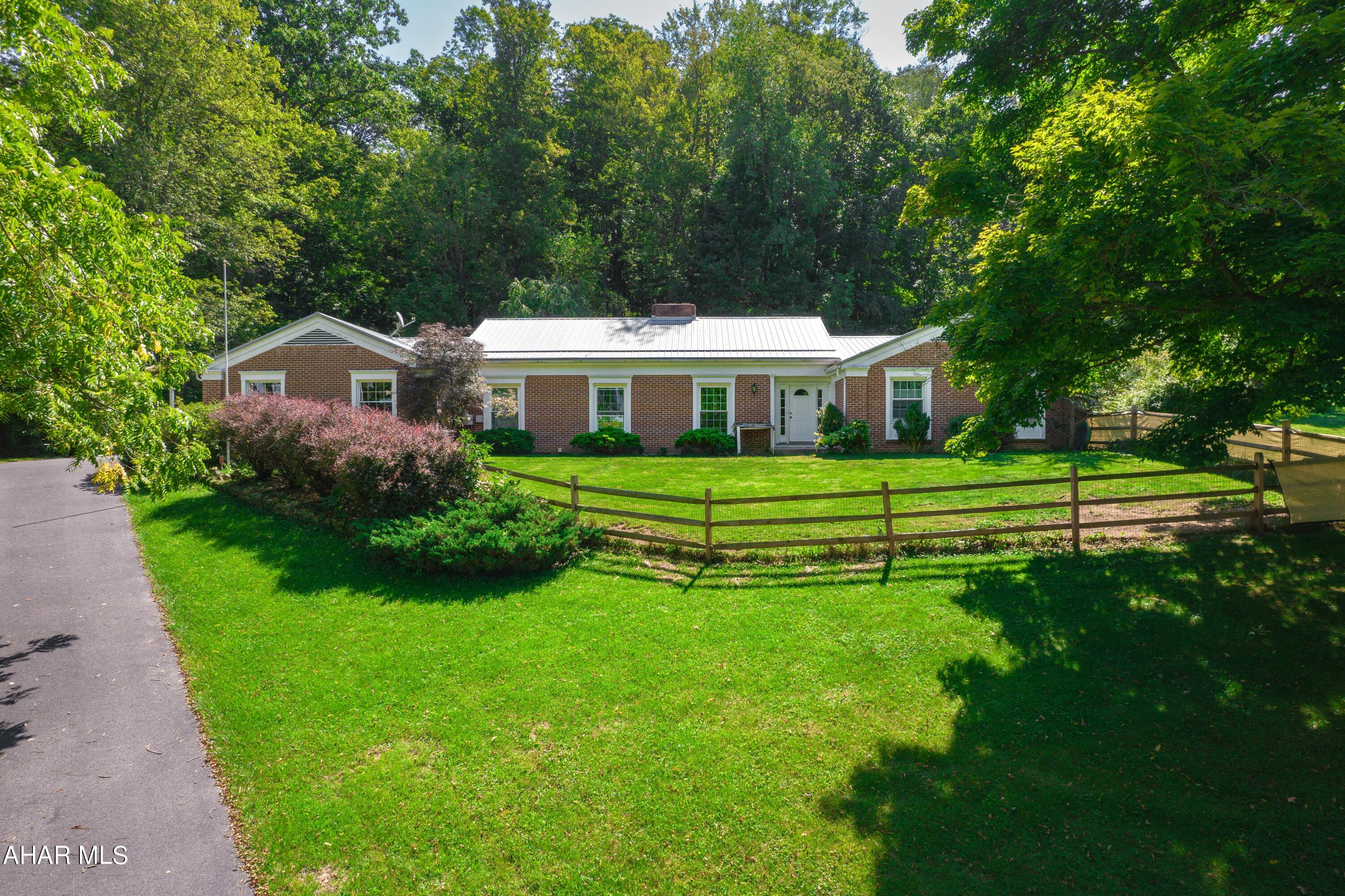 Beautiful brick rancher resting atop Meadowbrook Terrace in Bedford!! This quality built home rests on three lots consisting of 2.65 acres!! It offers a large entry foyer, living room with brick fireplace and floor to ceiling windows, kitchen with breakfast nook, formal dining room, family room with stone fireplace and wooded views, four bedrooms including an owner's bedroom with en-suite bathroom, another full bath and half bathroom, and a large laundry room complete with counters and sink. Partial basement with high ceilings, two-car attached garage, and a paved driveway. Updates include a new metal roof, triple and double pane insulated windows, front door, double stainless steel ovens, gutter guards, heat pump with central air-conditioning and insulation. 'Buderus' oil, hot water furnace, 200-ampere electrical service, public water and public sewer. This is a great Meadowbrook property just moments away from the schools, downtown area, Bedford Elks Country Club and Omni Bedford Springs Resort. SELLER PAID HSA HOME WARRANTY IN PLACE FOR BUYER!!