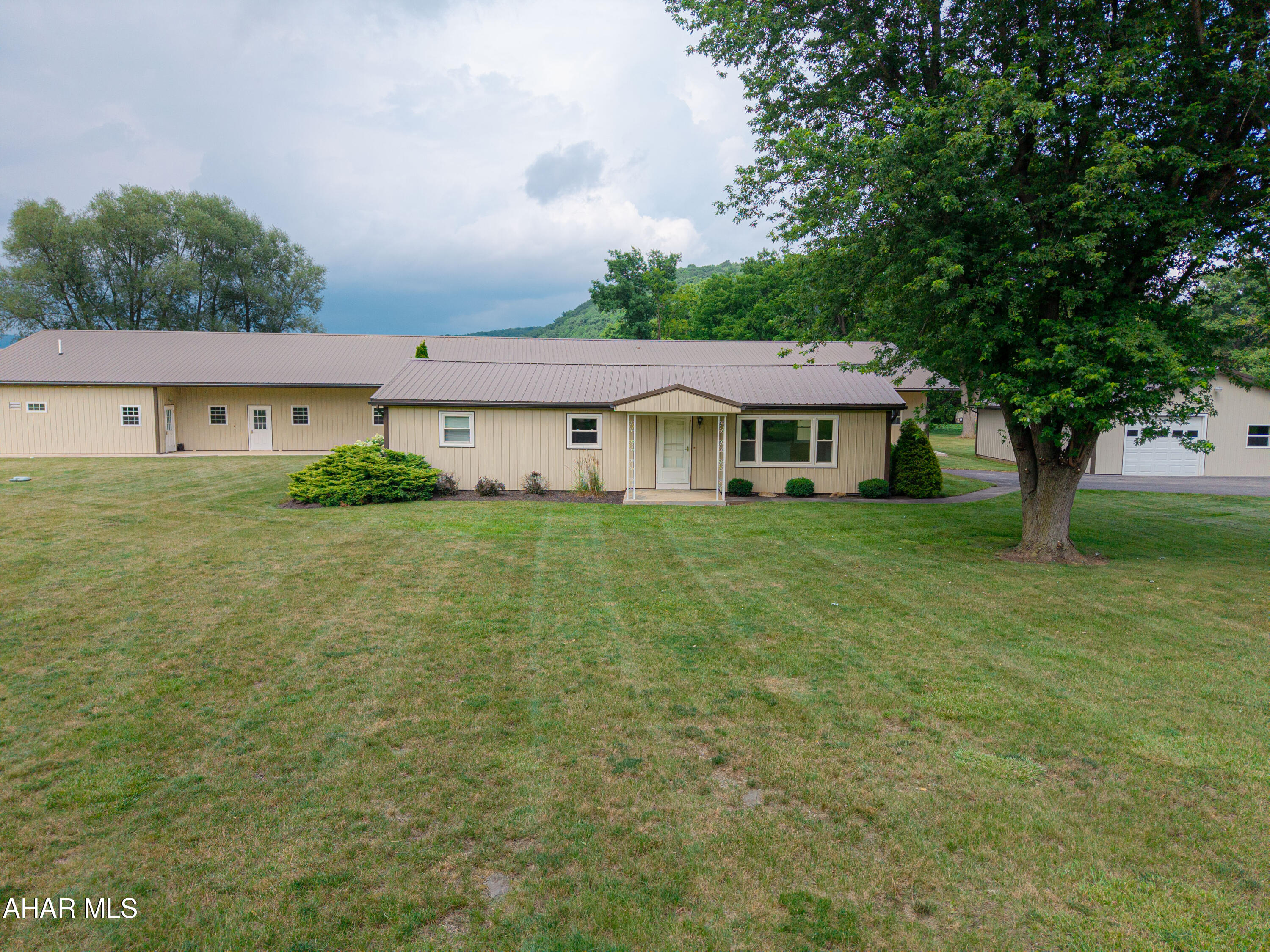 This property offers endless possibilities! This versatile property combines a comfortable ranch home with a substantial multi-purpose building, and a large garage, all in one convenient Bedford location. The 1,176-square-foot ranch home features three bedrooms, two bathrooms, a living room, kitchen with dining area, and laundry area, all for easy one-floor living. Additional features include replacement windows, a metal roof, metal siding, mini-split heat pump with air conditioning, electric baseboard heat, and many other updates. A detached 30' x 40' finished garage provides excellent space for vehicles, equipment, storage, hobbies, or a workshop. The highlight of the property is the impressive 5,636-square-foot detached pole building. Previously utilized as a bunkhouse, the interior bunk room partitioning has been removed, creating a large, mostly open free span, and adaptable space. The building features a finished interior, restrooms, kitchen area, laundry room, sprinkler system, and a 600-amp electrical service. The possibilities are extensive--consider a large garage, workshop, horse barn with stalls, guest quarters, apartments, storage facility, or space for a variety of business uses. Conveniently located near the Bedford County Airport, area business parks, I-99, and Route 220, while still just a short drive from downtown Bedford. Whether you're looking for a residence with exceptional storage and workspace, room for a business or hobby, or a multi-family complex, this one offers a combination of improvements and versatility that is difficult to find.