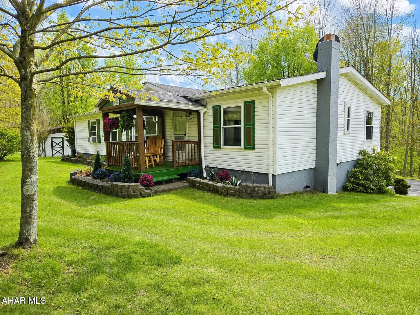 Welcome to 432 Black Snake Road in Dysart, where peaceful country living meets everyday convenience. Situated on 1.75 partially wooded acres that directly border State Game Lands, this property offers a rare opportunity to enjoy privacy, nature, and abundant wildlife right in your own backyard PLUS you'll have easy access to fishing, boating, camping, and outdoor recreation located just 15 minutes from Glendale Lake.

Step inside to a warm and inviting living room featuring a wood-burning fireplace and beautiful bay windows that fill the space with natural light while creating a cozy, country atmosphere. The kitchen provides generous storage with solid oak cabinetry and a pantry, and all appliances are included for added convenience. Just off the kitchen, you'll find a dedicated laundry room complete with washer and dryer and pantry storage.

The spacious primary suite is designed for comfort, offering a large walk-in closet and a private bath with a garden tub, separate shower, and vanity area. A versatile den or office space provides flexibility for work or relaxation, featuring French doors for privacy and sliding glass doors that lead directly to the deck.

Outdoors, the property truly shines! Enjoy the beauty of mature trees, perennials, and fruit trees throughout the landscape. The oversized wraparound back deck is perfect for entertaining or unwinding, complete with remote-controlled retractable awnings so you can comfortably take in the surrounding views and wildlife.

The full basement includes a deep two-car integral garage and ample storage space. Additional outbuildings, including a shed and a carport/garage, provide even more room for vehicles, recreational equipment, or hobbies.

If you've been searching for a private retreat that balances natural surroundings with accessibility, this property is ready to welcome you home.