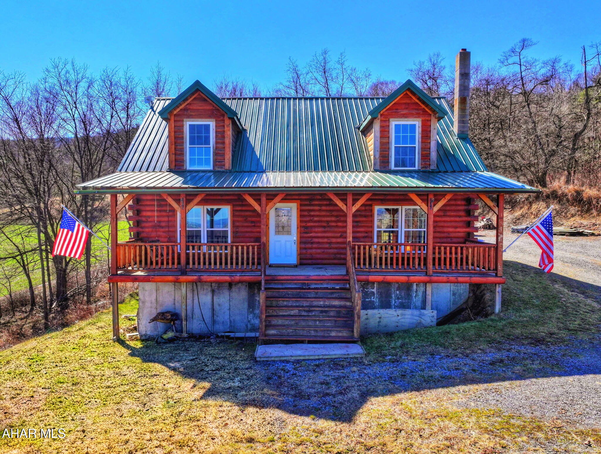 Enjoy peaceful country living in this charming Cape Cod-style log home, built in 2015 and situated on 1.66 acres in the desirable NBC School District. Constructed with Douglas fir logs and knotty pine interior, this home offers the warmth and charm of a mountain retreat while providing modern comforts.

The open-concept main floor features a spacious kitchen, dining, and living area designed for comfortable family living and entertaining. The kitchen showcases custom poured concrete countertops with an epoxy-stamped finish. Also on the first floor is a convenient guest half bath and a primary suite with a walk-in closet, large garden tub, and walk-in shower that are truly impressive.

Beautifully crafted staircase lead to the second floor, which includes a loft area with its own closet and prehung flat-screen TV--perfect for a playroom, office, or guest space. Two additional bedrooms and a full bath with tub provide plenty of room for family or visitors.

The basement offers additional living and storage space, including a large laundry room with built-in wine rack and room for sorting and folding. Two extra rooms provide endless possibilities, including the potential for a 4th bedroom. Plumbing hookups are already in place for an additional bathroom. Whole house reverse osmosis water system, wood/coal stove for heat and coziness. New double doors lead directly to the side yard, making it easy to move larger items.

Outside, enjoy stamped concrete entrances at both the front and rear of the home. Relax on the large covered porch, perfect for outdoor furniture and a porch swing while taking in beautiful mountain sunrises and sunsets. The porch floor is built with a durable, water and fire resistant subfloor for easy maintenance.

Nestled in the Allegheny Mountains, this property offers privacy, tranquility, and abundant wildlife, creating the perfect setting for peaceful country living.