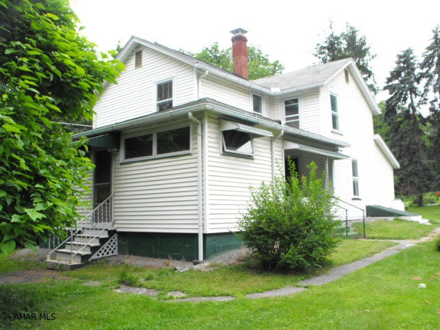 Tons of potential - live there while you update.  Very private setting on large flat lot.  Nice big rooms enclosed heated porch off kitchen.  Garage has electricity