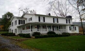 Older Two-story farm house remodeled and expanded in 1989. 10 to 15 acres to be surveyed, 2-car detached garage, bank barn, wagon shed, studio. Formal living room, formal dining room and family room w/large stone fireplace, beautiful hardwood floors, unique atrium with cement paved floor, wet bar and relaxing fish pond w/fountain.