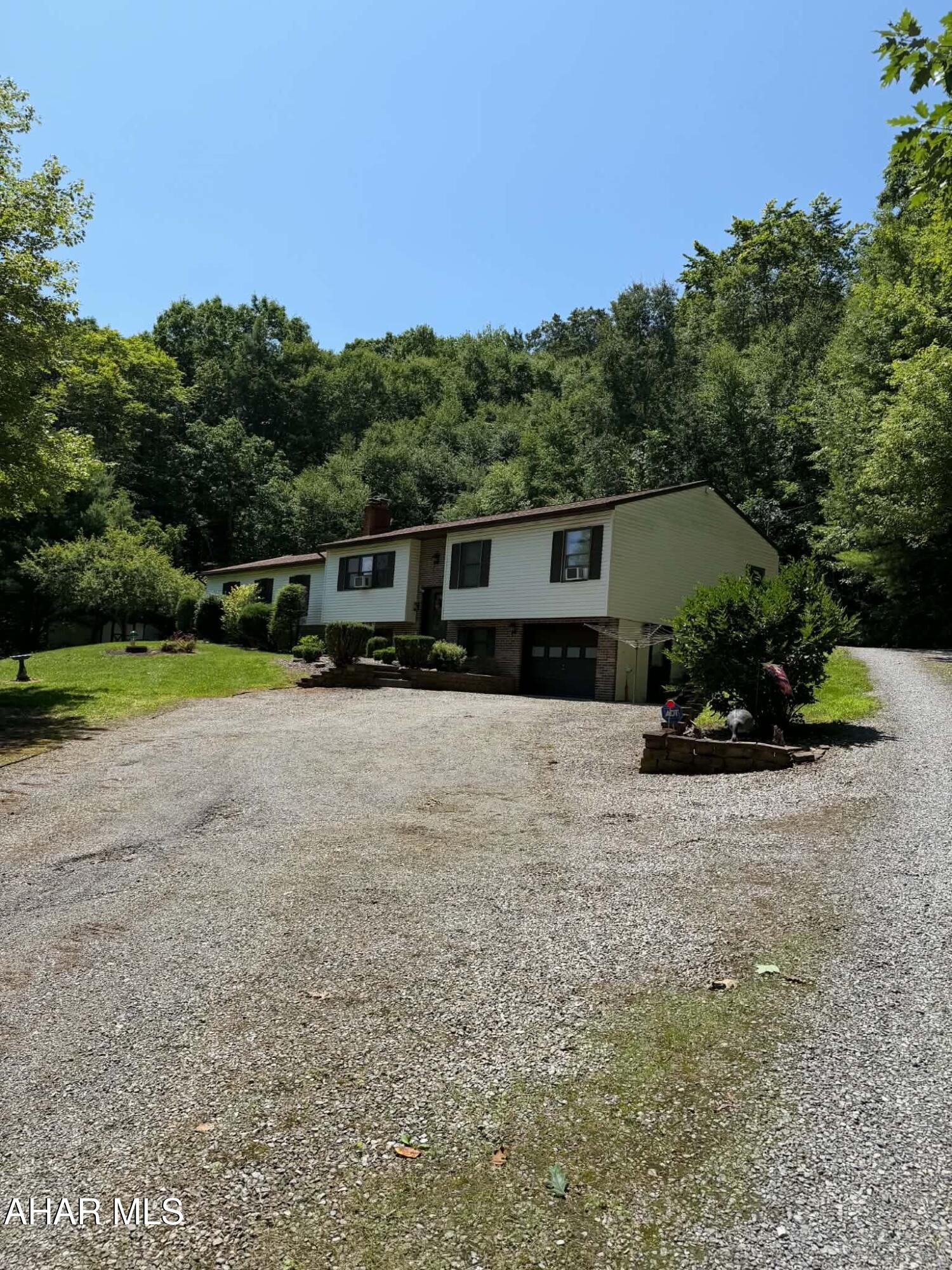 Escape to the peace and privacy of this well-maintained home on approximately 3.83 acres among mature trees on a beautiful wooded setting. A wraparound gravel driveway provides convenient access to both the front and rear of the home, offering ample parking and easy access to the attached garage.
A spacious enclosed covered patio creates the perfect place to relax, entertain, or enjoy the surrounding views in every season. Inside, you'll find comfortable living spaces filled with natural light, generously sized bedrooms, and a functional layout ready for your personal touch.
One of the property's standout features is the oversized attached garage complete with extensive built-in cabinetry, abundant workspace, and plenty of room for vehicles, equipment, hobbies, or storage.
With a beautiful blend of open yard and wooded surroundings, this property offers the privacy and tranquility of country living while providing the space and functionality today's buyers are looking for, all while remaining close by to local amenities. 

Additional adjacent lot also for sale measuring approx 1.85 acres