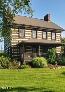 Now's your chance to own a piece of history with this pre 1800 original log home.  Originally owned by the Todd Family, this property has been called home by many over the years but most recently housed a charming gift shop until it closed in July of this year.  Although the house is move in ready, it would also make a great business location for a brewery, winery bed and breakfast, garden themed business
the possibilities are endless.
This property is located at the intersection of Routes 30 and 56 and sits next to the Bedford County Historical Society.

The charm of the house starts outside with the beautiful log and chink exterior, divided light windows with front and rear porches.  To complement the exterior, the house is surrounded by pretty gardens, a stone patio and a stone walkway.  There are also three outbuildings including a three car garage with loft, a cute cottage that would be the perfect She Shed or Man Cave and a barn with loft for additional storage.

The house boasts a custom kitchen with locally built hickory cabinets that are stained in a deep walnut and feature soft close drawers and pullouts; granite countertops add a rustic feel along with the beautiful farm sink.  Keeping with the historic feel of the house, the owners chose a vintage replica stove from Elmira Stove Works that feature a natural gas cooktop and electric oven.   The entire first floor features custom made random width hickory floors that were also made locally.  There are three stone fireplaces on the first floor that have been upgraded to burn wood, although they could easily be converted to gas logs.  The first floor bathroom features a shower stall unit, updated toilet and rustic vanity.

The second floor features three nice sized bedrooms with custom shutters and closet doors.  The second floor bath features a clawfoot bathtub, updated toilet, tile floor and rustic vanity.  There is also a full basement with washer/dryer hookups and a walk-up attic for additional storage
