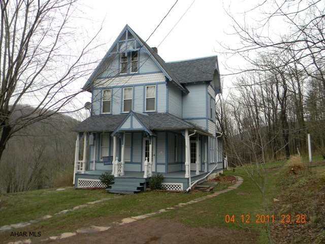 Early colonial home w/ detailed craftsmanship.  Light and airy interior w/ 4 bedrooms, living room, kitchen, dining room, bonus room and one bathroom.  Oil hot water heat and a Taylor outdoor wood furnace.  Large lot w/ an excellent view of surrounding mountainsides.  Additional 0.82 acre lot also available.  Property is conveniently situated next to a small public park.  Full walkout basement, shingle roof, frame and vinyl siding and covered porches.  A very nice buy!