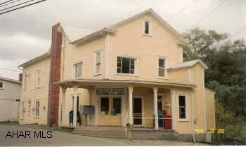 Great investment property. Bottom unit rented by U.S. Post Office. Top  unit has 2BR apartment. Large open area for storage in remainder of building. Roof is metal and rolled roof.