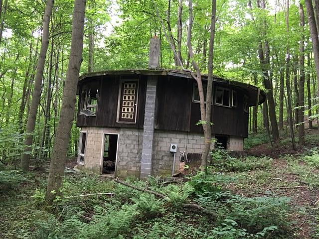 Hunters Paradise!!  Secluded, private, wooded land with a small round house that was being built and not finished---approx. 40 years old. There is a well and septic on the property.  Not sure if it was hooked up to the house or in what condition its in.  Selling "AS IS".  The electric is underground.  Deed states 19 more or less acres.