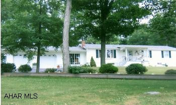 Lovely view with this well kept newly vinyled Ranch home with lots of space. Immaculate ranch home with a spectacular view. Large inviting sunroom with heat, foyer with Bruce hardwood flooring, birch cabinets and eat-at counter in kitchen. Basement has large family room with woodstove and summer kitchen. Lovely trees and landscaping, covered front porch with stamped concrete floor, convenient shed in back.