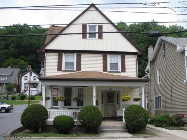 Watch the parades from your front porch or cross the street to the park! 2 1/2 story maintenance free Tyrone home w/ carport and detached garage. This home offers a spacious LR., DR.,  w/custom Cherry corner cupboard, EIK. w/ custom solid cherry cabinets, 1st fl. laundry and 1/2 bath! 2nd flr features 3 bedrooms and full bath plus a 2nd flr porch! Walk up attic storage & finished area in the basement too!! New furnace and updated windows, roof, siding and porch!!