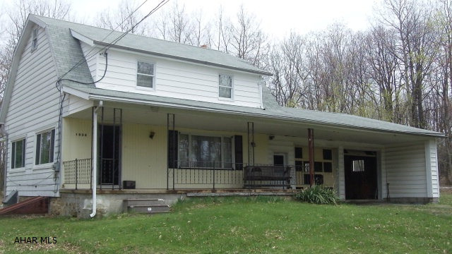 Perfect location - Private 9.8 acres of woods and open ground only nine miles from Bellwood and I-99.  Enjoy the privilege of privacy and rural living with easy access to Altoona, State College and everything in between.  Four spacious bedrooms with extra closet storage area.  First floor bedroom with private bath and direct outside access is a bonus for a live-in relative or caregiver.  There is a lot of room downstairs with three living areas, two that are partially open to each other.  Upstairs are three bedrooms with hardwood floors and a full bath. Walk up attic.  The two car garage has automatic garage door openers, an attached powder room, floor safe, and trolley hoist.  You have two options for the hot water heat: coal or oil.  Newly installed oil tank in the basement.