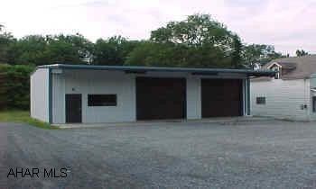 4 year old, commercial, steel building, 1410 sq', good condition, 2 overhead doors. Also, an older, 1 1/2 story house in need of repairs is included. Gravel parking lot. Good site for a small business, formerly used car sales.