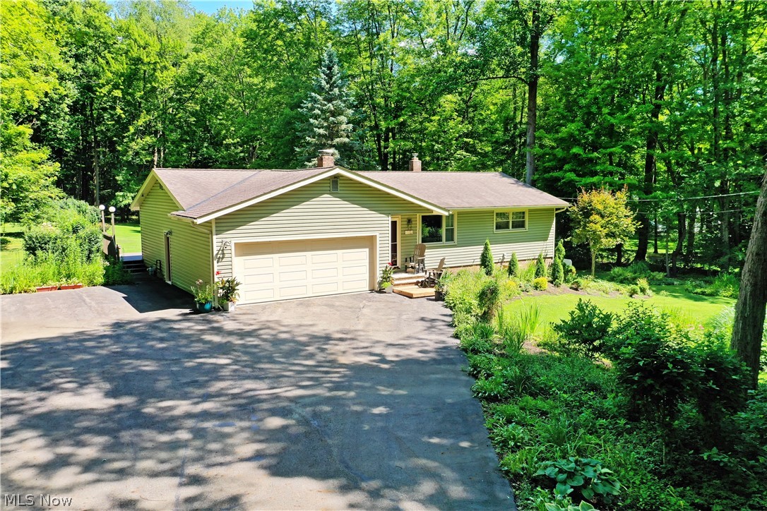 Immerse yourself in the peaceful, natural surroundings of this park-like Hiram property that includes 3 acres! Set far off the road in a tree-lined property that feels straight out of a story book, a sunny clearing opens to reveal the wonderfully appointed ranch home, trimmed in manicured landscaping and offering a must-see wraparound rear deck that’s poised to take in the views from any angle. A blacktop drive snakes through the trees to find both a two-car attached garage and additional outdoor parking. Inside the home, cherry-colored hardwood flooring fills the immediate living space as the prominent brick accent wall arches around the inset fireplace. Sunshine pours through the large picture window, cascading into the nearby formal dining room. Cook up your favorite meals in the bright and inviting, galley style kitchen where the neatly tiled backsplash runs between bright white cabinetry. Casual dining awaits the end of the hall-like layout, offering instant patio access. Around the corner, first floor laundry resides in a cozy full bath. Meanwhile, the main hallway transcends a trio of warmly appointed bedrooms, each with soft carpeting and casual surroundings that exude comfort. They are joined by a deep-set full bath at mid hall and its sleek half panel walls. Down below, a full basement includes a lavish stained wood bar area with plenty of adjacent rec space. Storage and additional utilities complete the level. Notable updates include new roof, vinyl siding and carpet in 2011, windows 2012, new sump pump 2013, hot water tank 2021, whole house generator and instant hot water heater for kitchen and laundry 2024, and so many more!