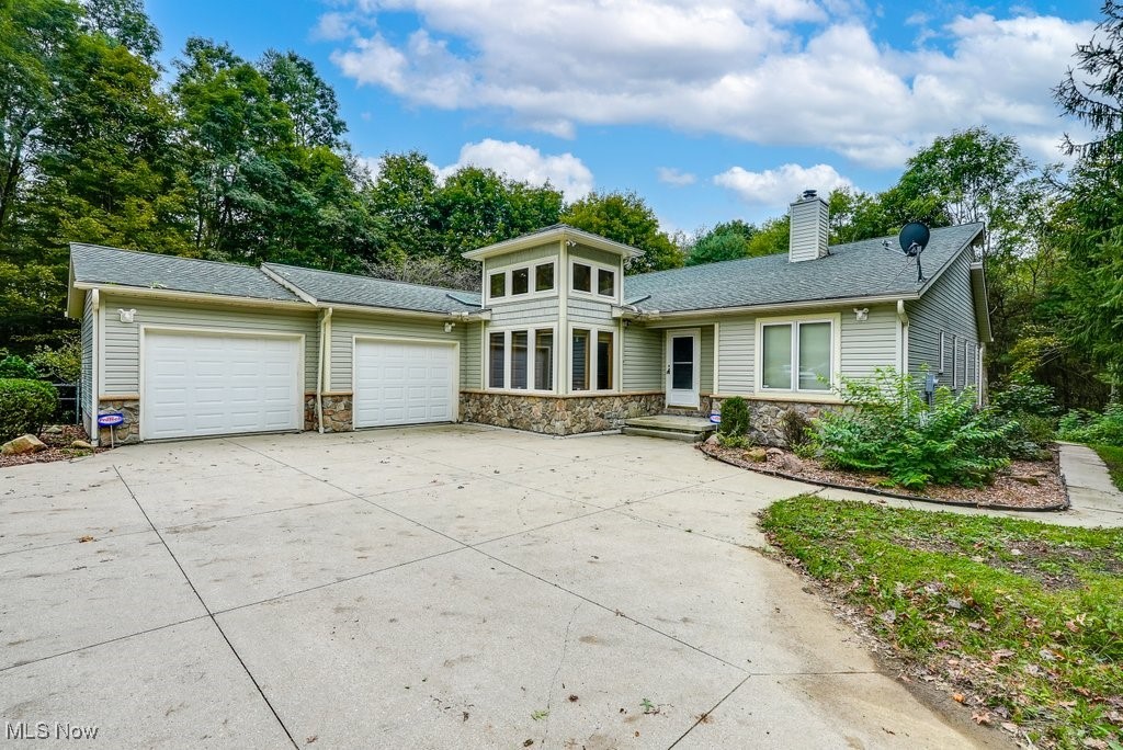 Discover the perfect blend of country living and modern convenience in this stunning Custom-built home, nestled on private and secluded wooded 4+ acres in Freedom Township! This One-owner property provides convenient one-level living and a spacious layout with 3 (possibly 6) bedrooms and 3 Full Baths. Three bedrooms and a full hall bathroom are on the main level and include a Luxurious master suite with direct access to the Great Room, full bath, 1st floor laundry/mudroom and an exterior deck that connects to a sizable Sunroom. The large and open Great room is the heart of the home and features vaulted ceilings with transom windows, a wood burning fireplace and allows access to the sunny veranda that connects to another bonus room (possibly 4th bedroom), a wet bar, and the newly added Sunroom. Enjoy abundant natural light in the recently added eat-in kitchen, adorned with a floor to ceiling wall of windows, skylight, wood flooring, and neutral paint throughout. With nearly 2300 sq ft of above grade living space, the fully-finished lower level doubles the living area and includes a large recreation room, 2 bonus rooms with closets, a huge separate walk-in closet, and a third full bathroom. This all-electric home features the energy efficiency of the geothermal heating and cooling and is equipped for handicap accessibility including hand rails in the master bathroom and a ramp from the garage, which can be removed to restore the two-car garage. Outside, a large 32x16 barn provides additional storage or hobby space. Conveniently located near the Ohio Turnpike, Route 44, and NEOMED, enjoy the tranquility and privacy of rural living while staying close to essential amenities. This is your opportunity to own a slice of serene paradise! **DO NOT drive up to the property without a confirmed showing with a real estate agent**