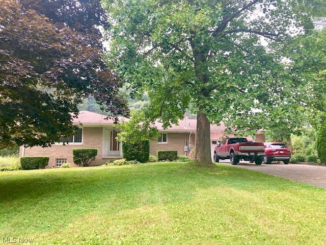 Welcome to your own private retreat! Nestled on two beautifully maintained acres, this all-brick ranch offers the perfect blend of peaceful country living and everyday convenience. Towering evergreens create a secluded front yard, while a wooded backdrop provides exceptional privacy and a tranquil setting you'll enjoy year-round.
Perched atop a gentle hill, the home offers timeless curb appeal with an attached two-car garage and convenient concrete turnaround. Step inside to discover a spacious living room featuring gleaming hardwood floors, sliding doors to a cozy balcony, and a striking wood-burning fireplace with stove insert—the perfect place to gather on cool Ohio evenings.
The adjoining dining room is accented by an elegant chandelier and flows effortlessly into the fully applianced kitchen, where abundant cabinetry, generous counter space, and a breakfast bar make both everyday living and entertaining a pleasure.
Three comfortable bedrooms and one and a half baths complete the main level.
The finished walk-out lower level dramatically expands your living space with an enormous recreation room featuring a second wood-burning fireplace, an impressive oak wet bar, and multiple seating and entertaining areas. This amazing room opens directly to the patio, creating an exceptional indoor-outdoor lifestyle that's perfect for family gatherings, game days, or relaxing summer evenings.
Outside, the beautifully landscaped two-acre property offers endless opportunities to enjoy nature, entertain guests, or simply unwind in complete privacy. A large detached outbuilding provides space for two additional vehicles, a workshop, hobby space, or extra storage.
If you've been searching for a home that offers privacy, character, and room to make lasting memories, this one-of-a-kind property is ready to welcome you home.