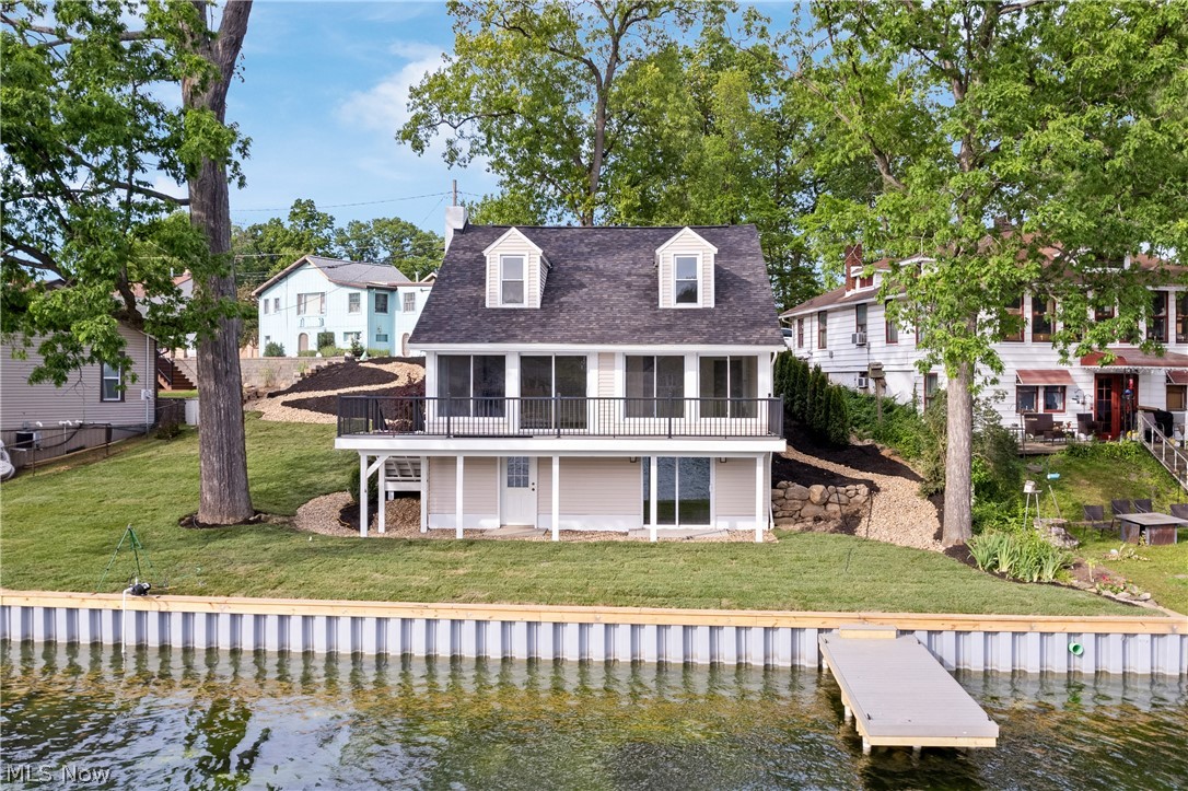 Welcome to your dream waterfront oasis on West Reservoir! Celebrating a century of character, this fully renovated "100 years young" home beautifully blends timeless charm with high-end modern luxury. Offering 3 bedrooms and 2.5 bathrooms, the interior showcases a gorgeous open-concept kitchen complete with show-stopping quartz countertops and brand-new stainless steel appliances. The home's thoughtful main level layout continues on and includes a massive greatroom, cozy fireplace for cooler evenings, a half bath for guests and the ultimate convenience of main-level laundry. The upstairs has two bedrooms and features a luxury spa-like bathroom complete with a standalone soaking tub and a sleek walk-in shower. As you move through the home, the magnificent greatroom's picture windows frame breathtaking views of the water, flooding the space with natural light. Step out of the greatroom onto the oversized deck overlooking the lake—the absolute perfect vantage point to capture amazing west-facing sunsets. Downstairs, the walkout basement provides seamless access to the outdoors, where you will find stunning, professional landscaping leading down to the water. Boasting 110 feet of pristine lakefront, the property features a brand-new seawall and a private dock, making it a paradise for boating and water recreation. Additionally, the generous lot size offers plenty of space to add a detached garage. Truly a rare find in the Portage Lakes area, this turnkey property is ready for you to move right in and start living the lake life.