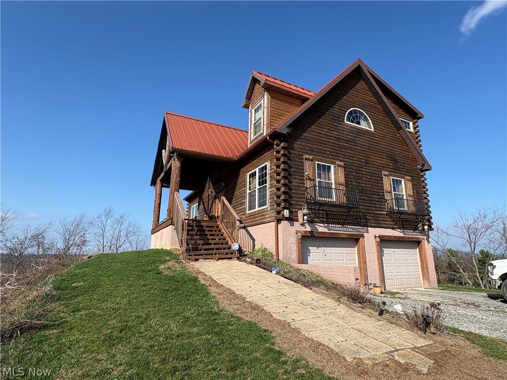 Extraordinary custom log home situated on 3.65 scenic acres on one of the highest points in Monroe County, just minutes from Woodsfield and Lewisville. Built in 2009 with exceptional craftsmanship, this home features cedar-stained half logs for superior insulation and a seamless copper-coated stainless steel roof with 50-year warranty.

The dramatic 28’ vaulted great room showcases a floor-to-ceiling stone fireplace, massive peeled hickory tree support, and custom antler chandelier. Gourmet kitchen offers custom hickory & pecan cabinetry, mica countertops, Italian stone flooring, and stainless appliances.

The loft-style master suite includes panoramic views, office area, wraparound cedar walk-in closet, and spa bath with granite tops, hammered copper vessel sinks, Jacuzzi tub, and onyx tile shower.

Outdoor living features multiple covered porches with copper roofs, a deck with 6-person Jacuzzi, and breathtaking valley views extending into West Virginia. Additional highlights include a finished basement with heated floors, wine cellar, 4-car walk out garage, whole-home surround sound, and ADT security system.  Whole house sound system.

A truly one-of-a-kind luxury log retreat offering privacy, craftsmanship, and incredible views.

*** SELLER DOES NOT OWN GAS AND OIL RIGHTS***
