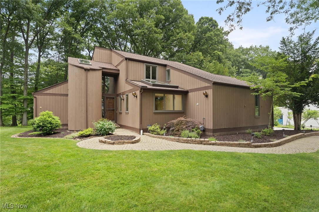 Don’t Miss This Exceptional Opportunity in Brecksville! Located on a beautiful, private street just minutes from downtown Brecksville, this over 3,000 sq ft, 4-bedroom, 2.5-bath contemporary home blends architectural charm with modern convenience. From the moment you arrive, you will admire the manicured lot, low-maintenance landscape, and well-maintained exterior of this home. You're welcomed by a decorative 8-foot panel door that sets the tone for what’s inside. Step into a dramatic two-story foyer with a curved staircase that gracefully ascends to the upper level. Just off the entry, a sunken formal living room and open dining room combination create a perfect flow for entertaining. The enormous 26' x 15' family room with a granite-tiled fireplace provides a cozy yet spacious gathering area for any occasion. The eat-in kitchen is a chef’s delight, featuring a central island and plenty of wall-to-ceiling cabinetry for storage, and enjoy the function and reverse osmosis water system! Adjacent to the family room is a first-floor laundry room that cleverly doubles as a wet bar, adding extra versatility and convenience for entertaining. Upstairs, the 21' x 18' primary suite is a true retreat, featuring his-and-hers walk-in closets and a spacious master bath complete with a soaking tub. Three additional large bedrooms upstairs offer flexibility for family, guests, or workspace. The partially finished lower level provides bonus space perfect for a home gym, office, or media room. Step outside to enjoy the expansive deck, accessible from the family room—ideal for relaxing or hosting in a private outdoor setting. This home was lovely custom custom-designed by the owner and cherished through the years, it's more than just a house—it's a forever home. Schedule your private showing today!