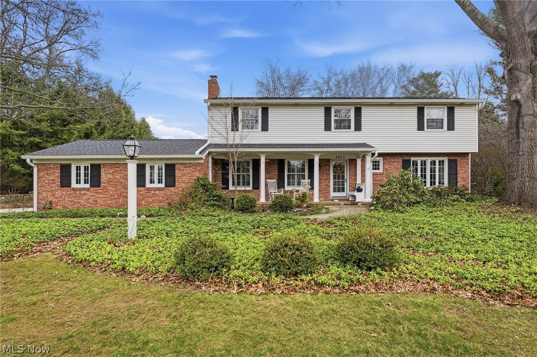 Welcome to this stately colonial where timeless character and thoughtful updates come together in a warm, inviting setting. From the moment you arrive, the expansive front porch sets the tone for the home’s classic charm and welcoming feel. Inside, rich hardwood flooring and custom built-ins create a sense of craftsmanship throughout the home. The living room features built-in bookshelves surrounding a beautiful wood-burning fireplace and a cozy dining nook, offering the perfect place to gather. A second spacious living area provides flexibility for entertaining or relaxing, while the dining room is elevated with elegant grasscloth wallcoverings that add texture and warmth. The kitchen offers abundant cabinetry, quartz countertops, pantry storage, and a suite of stylish GE Café appliances, blending modern performance with timeless design.  The bright three-season room provides a wonderful space to enjoy morning coffee or unwind while overlooking the backyard. Upstairs, the home continues its refined feel with generously sized bedrooms and beautifully updated bathrooms. The primary suite includes a private bath with heated floors, walk-in shower, skylight, and walk-in closet. The main hall bath features a double vanity, built-ins, and a tile surround extending to the ceiling. Outdoor living is just as special, with a professionally designed brick patio and walkways, mature landscaping, and thoughtfully installed outdoor lighting that enhances both the front and backyard. Additional updates include replacement windows with a transferable warranty and whole-house insulation for added efficiency. With classic colonial architecture, extensive built-ins, modern updates, and beautifully designed outdoor spaces, this home offers timeless style and comfort both inside and out.