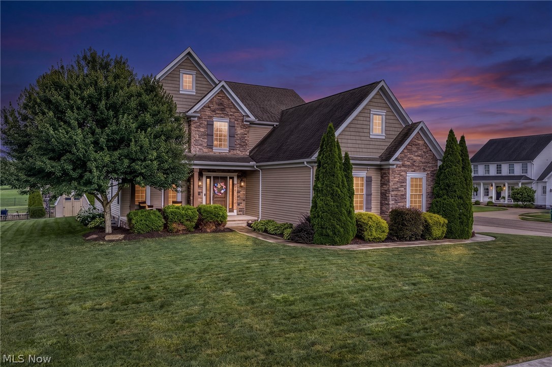 Welcome home to this stunning 4-bedroom, 3.5-bath colonial on a beautifully landscaped corner lot in the highly desirable Heritage Glen community, located in the award-winning Lake Local School District. A welcoming covered front porch and dramatic two-story foyer highlighted by an elegant chandelier create an unforgettable first impression. Offering over 3,600 square feet of finished living space, this beautifully maintained home combines timeless style with modern functionality. The spacious kitchen is the heart of the home, featuring a large center island, hardwood floors, double wall ovens, a 5-burner gas cooktop, decorative metal backsplash, and abundant cabinetry. It opens seamlessly to the inviting great room with a gas fireplace and custom built-ins, as well as a bright morning room overlooking the backyard. The main level also features a formal dining room, convenient first-floor laundry with utility sink, and a half bath for guests. Upstairs, the impressive primary suite offers double doors, a tray ceiling, an oversized walk-in closet, and a luxurious bath with dual vanities, a soaking tub, and tiled shower. Three additional bedrooms share a full bath with double sinks and a separate shower area. The finished lower level is an entertainer's dream, complete with a custom wet bar, theater area with projector, a full bathroom, and a separate flex room perfect for a home gym, playroom, or office. Outside, enjoy the covered deck, concrete patio, and beautifully landscaped yard complete with an invisible pet fence, plus a storage shed, oversized driveway, and 3-car attached garage. Additional highlights include a premium tankless water heater and like-new carpet throughout the first and second floors. Heritage Glen offers sidewalks, lighted streets, and a scenic community pond. This exceptional home truly has it all. Call today to schedule your private showing!