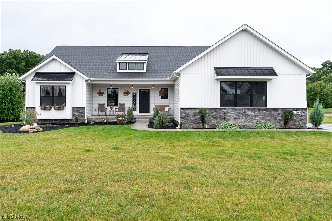 Welcome home to this beautiful custom-built Grisez 3 bedroom, 2 bath split ranch home in Hartville!  Step inside the front door and enjoy the open-concept, rustic farmhouse main living area with distressed wood beam accent and vaulted ceiling.  The great room boasts natural lighting and has gas fireplace with gorgeous stone surround and distressed wooden mantle. The kitchen has quartz countertops, walk-in pantry, stainless steel appliances, and a massive island with farmhouse sink, pendant lighting, and additional seating. The dining space is large, open and ready for entertaining.  Off the dining space is a patio door that leads you to a 13x16 covered porch with recessed lighting and outdoor fan. Additional outdoor living space includes a flagstone patio with fire pit and covered front porch. The large primary bedroom is private with attached bath with dual sinks, quartz countertops, tile walk-in shower and 11x16 walk-in closet. Laundry room has large stainless steel utility sink, cab