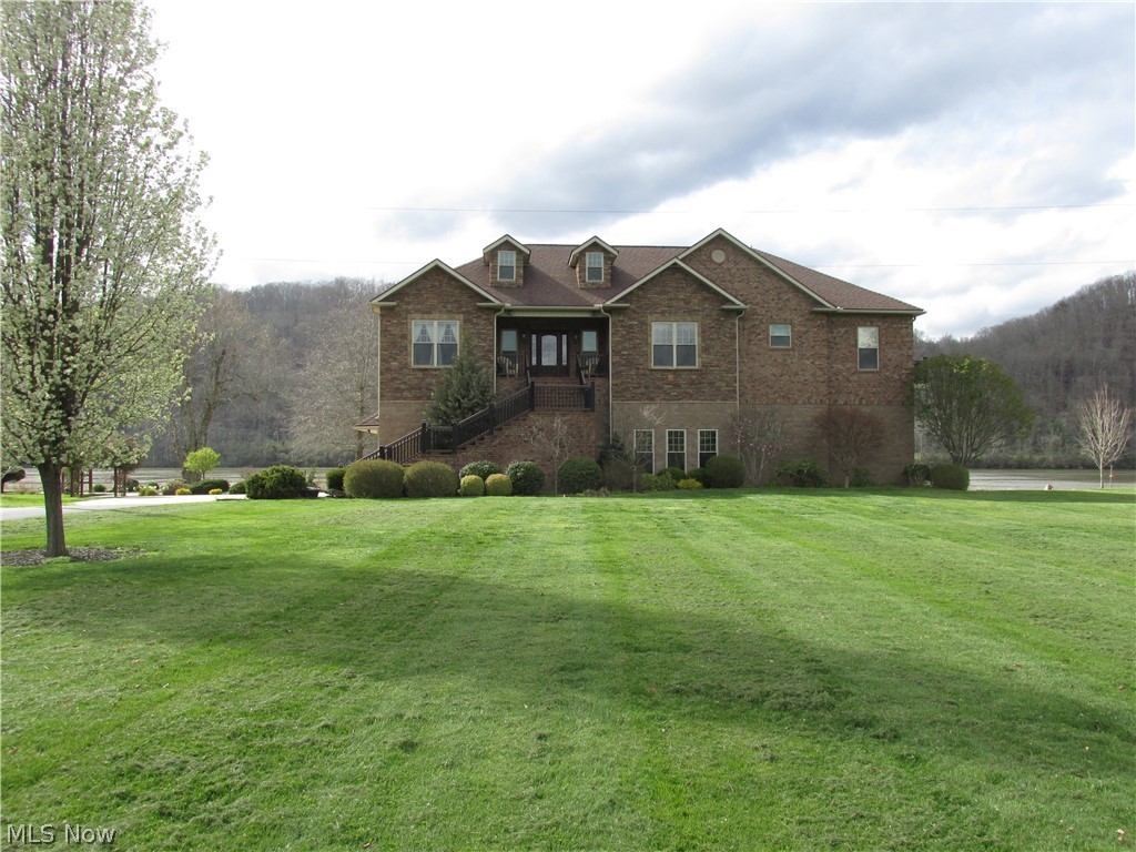 This is a little heaven on earth, in your quiet, private location with a beautiful view of the Ohio River and Wayne National Forest.  This home is of the highest quality with over 2600 sq. ft. of living space, hardwood floors throughout, granite counter tops, stainless steel appliances, a super handy drawer freezer and an elevator to take you from the garage or basement to the first floor.  You can walk out of the Master BR to the deck overlooking the river and enjoy the quiet of the morning.  The garage under the house has a heated concrete floor, so you can be down there all year around.  If you like to entertain and talk with everyone the open concept of living, dining and kitchen area is ideal.  Summer evenings may be the best, with the screened in outdoor entertainment area with a fireplace to host family gatherings, or small intimate close friends.  If you want to feel like you're on vacation all year around this home is for you!  Over 300 feet of river frontage, an extra unattac