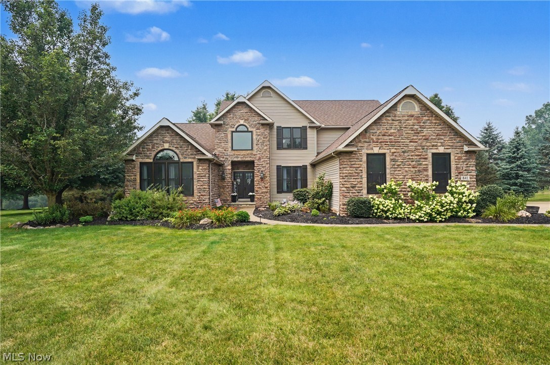 Welcome to this exceptional 4-bedroom, 3.5-bath colonial nestled on a picturesque 1.5-acre lot in the highly desirable Windy Hill Estates! Offering 2,949 square feet above grade plus an additional 1,250 square feet of beautifully finished basement space, this home combines timeless elegance with modern updates and exceptional living space.
Step inside to soaring 18-foot ceilings and an abundance of natural light that fills the open and inviting floor plan. The formal dining room showcases beautiful hardwood floors and flows seamlessly into the impressive family room, featuring a breathtaking wall of windows and a stunning floor-to-ceiling stone fireplace. The spacious kitchen is designed for both everyday living and entertaining with hardwood flooring, granite countertops, updated appliances, and ample cabinetry. Just off the kitchen, the four-season sunroom provides the perfect place to relax while overlooking the peaceful, private backyard.

Convenience meets luxury with a first-floor primary suite featuring a beautifully updated ensuite bathroom complete with a Jacuzzi tub, separate shower, and a large walk-in closet. An additional first-floor bedroom or private office, along with a laundry room, completes the main level.
Upstairs, an open loft overlooks the dramatic family room below and leads to two generously sized bedrooms connected by a Jack-and-Jill bathroom.
The finished lower level is an entertainer's dream, offering a spacious recreation room with an ideal theater area, a wet bar, a dedicated workout room, a full bathroom, and multiple storage rooms.
Step outside to your own private retreat featuring a beautiful patio, expansive backyard, and a cozy fire pit—perfect for relaxing evenings or entertaining family and friends.
This is a rare opportunity to own a meticulously maintained home offering space, privacy, and luxury in one of Wadsworth's most sought-after neighborhoods. Schedule your private showing today!