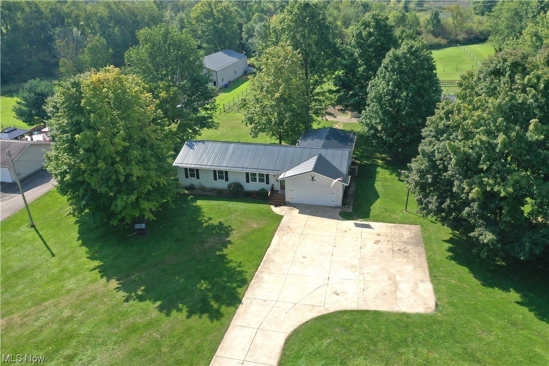 2304 St Rt 303, Streetsboro -- an impeccable 3 bed/2 full bath ranch-style home situated on nearly 4 acres. Horse/Farm property with a 10'x28' two-stall horse barn with a tack room + a loft w/electric with pastures. Partially wooded lot. Full fence. 2 car attached garage & a 2 car (24'x24') detached garage/outbuilding with 220 electric + a woodburner. Inviting curb appeal & front porch. Over 1,900sqft of living space with an open floor plan. Spacious living area w/crown molding. Eat-in kitchen featuring quartz, butcher-block island, stainless-steel appliances & plenty of cabinetry + under cabinet lighting. There's an add'l living area adjacent to the kitchen w/ built-in shelving leading out to the impressive custom covered stamped patio. Updated guest bath leading to the 3 bedrooms. Primary bedroom with an ensuite w/ a remodeled bath. SO MANY UPDATES! ('22-'23) Carpet, pergo flooring, bathrooms kitchen revamp, kitchen island, appliances, paint throughout, fixtures, HWT, AC, Full House