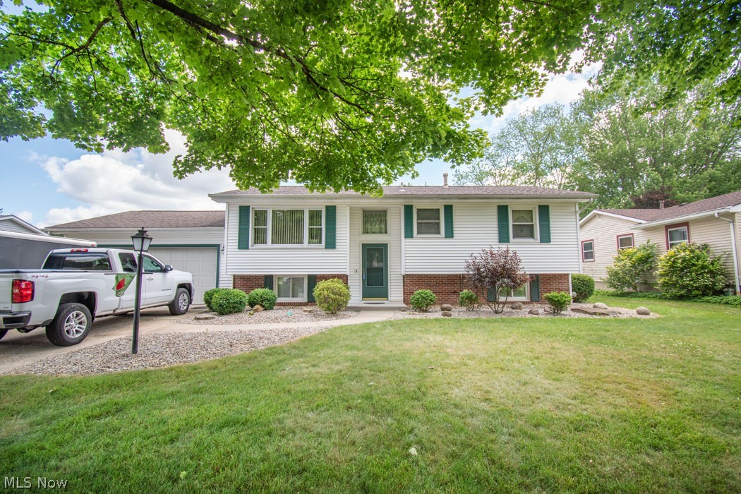 Beautifully landscaped Bi-Level home tucked away in a scenic neighborhood.  The living room boasts a large picture window that lets in tons of light.  Enjoy the screened-in porch in the morning sun or relax after work in the evenings.  The cement patio is perfect for entertaining family and friends.  The large outbuilding is great for a workshop and storage which includes a covered patio.  All this plus a one year Home Warranty.