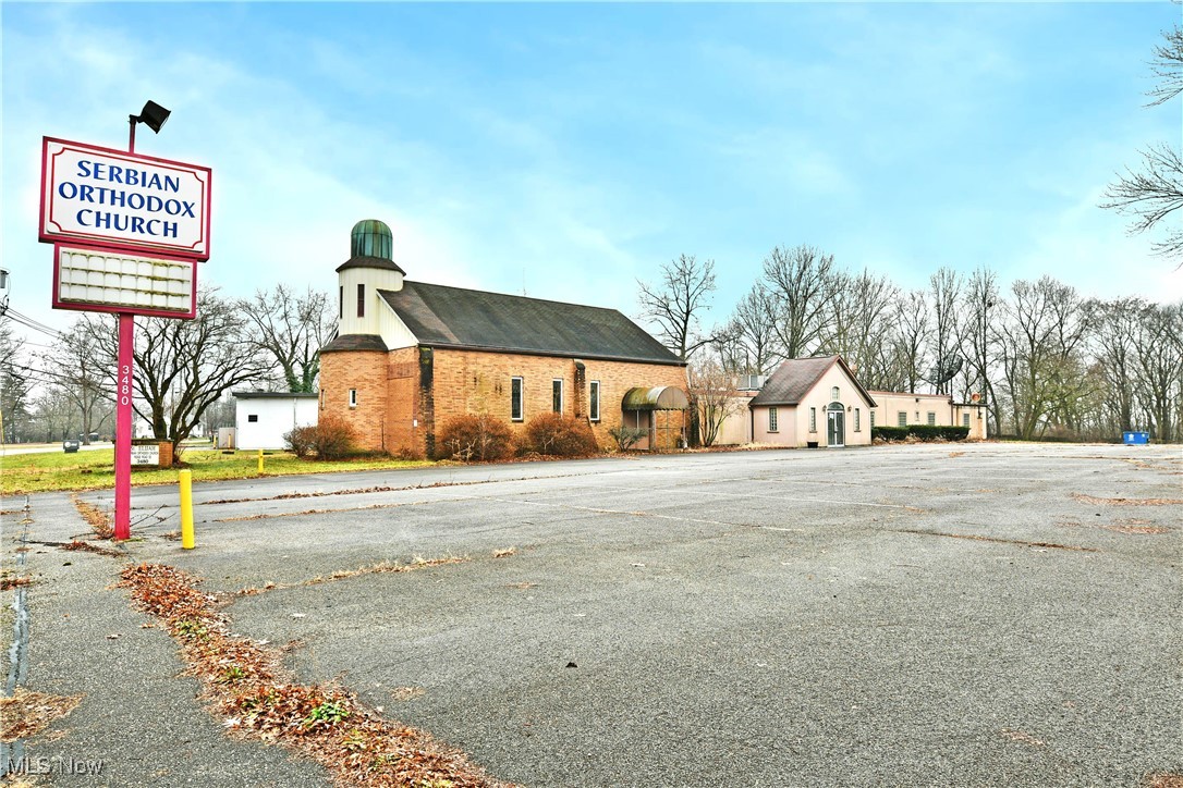 Find your fellowship with this unique opportunity, ready to continue as a place of worship, converted into a banquet center or whatever your creativity desires. The current turn-key style operation provides all the right attributes that are sure to capture your attention. A central location places the building just moments away from main thoroughfares, providing easy access to its impressively sized and gated parking lot. The pre-lit signage is a welcome sight for advertising as further into the property, a large storage shed and accompanying concessions with a covered patio area both add to the allure. A rounded brick steeple creates an instant sense of curb appeal while multiple entrances include both direct access to the congregation and a prominent vestibule that opens to an expansive dining hall. Here, a rearward stage showcases a great centerpiece for weddings, bingo, live music, and more. At the front of the hall, a corner bar joins a huge serving window that peers into the central kitchen. Industrial grade coolers, stove tops and ovens ensure restaurant worthy serving capabilities as steel tables and long countertops provide tons of prep space. A rearward expo room finds additional prep and beverage solutions as it yields a hidden staircase that overlooks the parish with overhead storage. The main hall includes restrooms and utility access. Stained glass windows and two rows of pews look towards the carpeted altar, hidden by elegant woodwork. Behind the stage area office space is available for day-to-day clerical work.