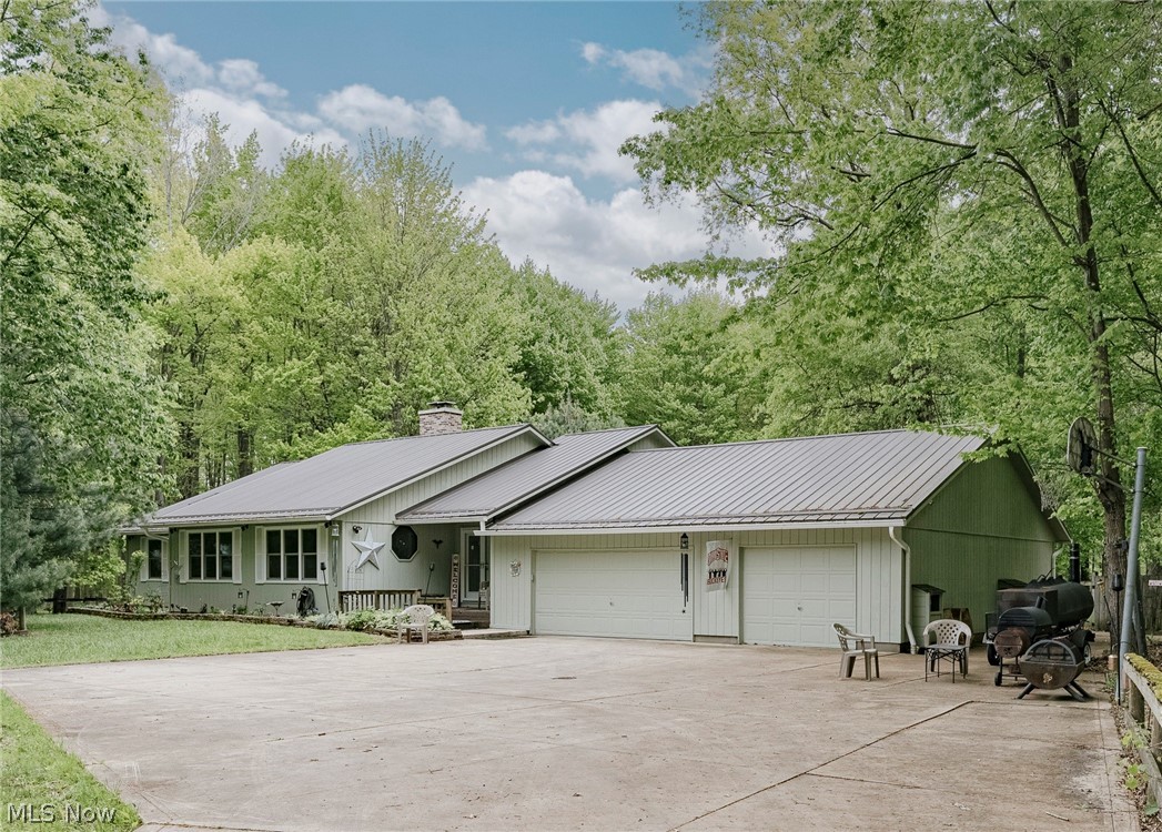 Welcome to 7814 Poorman Rd in Vermilion, an expansive ranch set on a quiet wooded lot with a stocked pond and generous yard space. A winding driveway leads to the home, nestled in a private, wooded setting. Updated double front doors open into a welcoming foyer. Just beyond is a spacious living room filled with natural light. This inviting space features a brick fireplace and a distinctive octagon window with leaded glass detailing. The living room flows into an open remodeled kitchen and dining area with wood flooring. The kitchen and dining spaces have been thoughtfully updated with newer cabinetry, backsplash finishes, updated fixtures, an oversized double sink, and a modern faucet, along with refreshed dining room details including new drawers, doors, hinges, and door pulls. New sliding glass doors from the dining area lead to the back deck, creating easy indoor and outdoor living. Down the hallway are three bedrooms and two full bathrooms. The front bedrooms are generously sized and feature skylights for added natural light. The primary suite offers a spacious bedroom, walk-in closet, and a remodeled ensuite full bath with fresh paint and updated finishes. A second full bathroom is conveniently located near the additional bedrooms. On the opposite side of the home are the laundry and mud room along with a convenient half bath. The full basement provides substantial storage space and added flexibility. Outdoor features include a large back deck overlooking the expansive backyard and fenced area. The property also includes an outbuilding and a three-car attached garage with workshop and storage space. Extensive renovations and mechanical improvements throughout the home add both comfort and peace of mind, including a newer metal roof with updated plywood on the back half of the home, new skylights, bathroom exhaust fans vented outside, and updated plumbing work. This home offers privacy, space, and a peaceful setting with room to make it your own in Vermilion!
