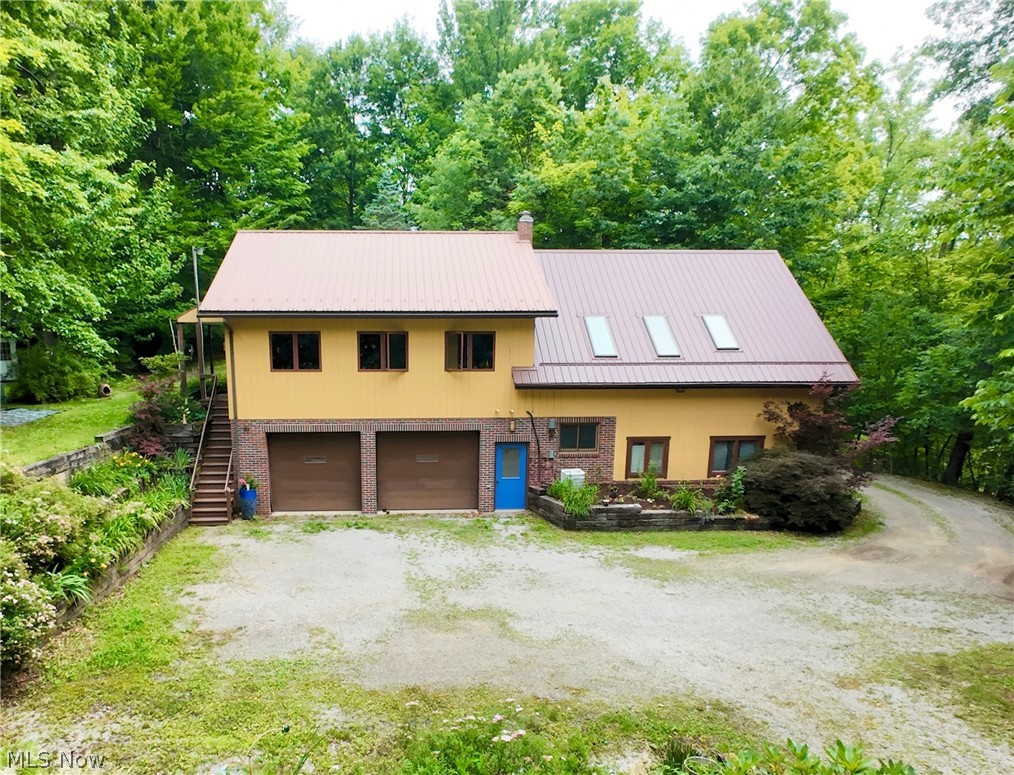 Online Auction begins ending Thursday, July 30th, at 6:00 PM. Private secluded home on 8.46 acres with a spring fed pond situated amidst a nature sanctuary. The home, built in 1985 has a total of 1,740 sq. ft. of living space with the main floor having a kitchen, small dining area, office area, large family room, bedroom and a full bath. The lower level is host to 3 bedrooms, full bath, entry room and a 2 car garage. The exterior of the home is brick, wood siding and a metal roof. Utilities include spring water, septic, natural gas forced air furnace, central air, whole house generator, outdoor shower and a composting toilet that is approved by the health department. There are several storage sheds and a carport. The land is a mix of open and wooded acreage with walking trails throughout. The pond is spring fed and is stocked with bluegill, bass, white amur and koi. Whether you're seeking a full-time residence, weekend getaway, or private retreat, this exceptional property is truly a natural oasis in the heart of Holmes County.