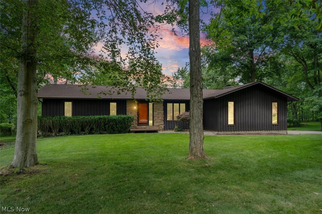 Timeless home with a Frank Lloyd Wright feel! Step into this stylish mid-century modern ranch home on a serene .40 acre lot with tall trees and plenty of greenspace. Enjoy single-story living with hardwood floors, stone fireplace, 2 full baths, and primary suite with ensuite full bath. Well-maintained with updated windows, central air, appliances, and more. Full basement has so much room for everything fun: pool table, workbench and plenty of storage. The extra large deck overlooks private backyard with wetlands views & no neighbors. Quiet street, no HOA. This home is for you if you want a crisp, freshly painted, move in ready Tallmadge ranch. It's truly a rare find!
