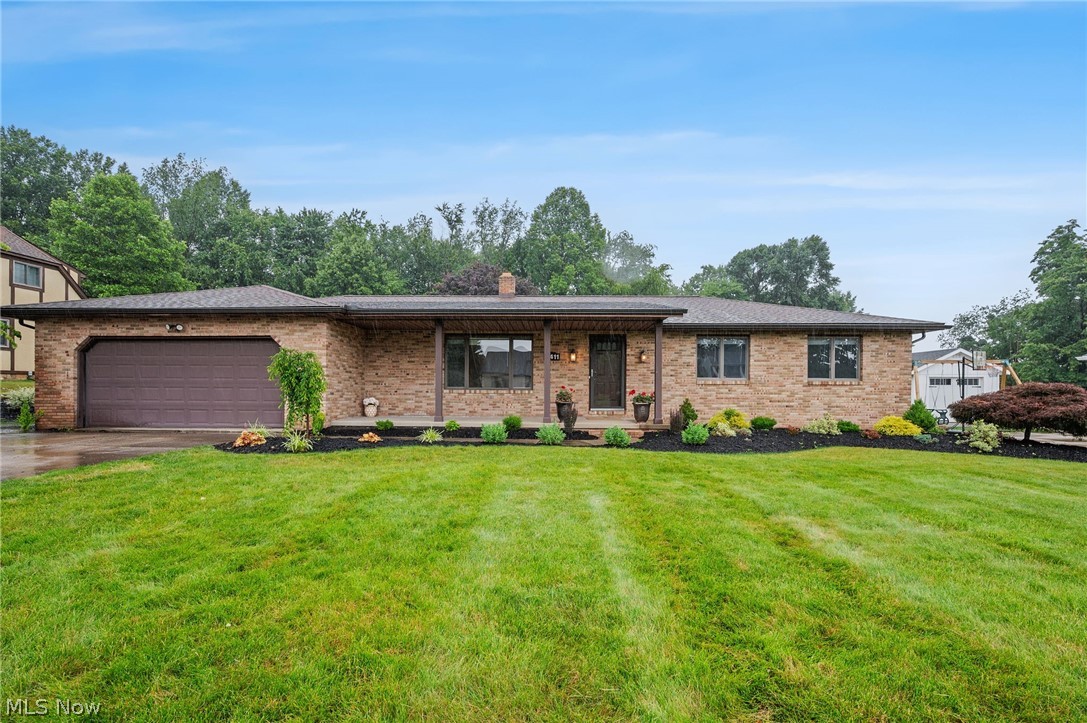 Brick RANCH with a finished lower level situated on a picturesque .51-acre park-like lot in the highly desirable Green School District, offering the perfect combination of space, privacy, and versatility with professionally designed interior and exterior features. This well-maintained home features 3 bedrooms, 2.5 baths on the main level, a front living room that can also serve as a formal dining room, and a separate family room with crown molding, exposed beams, and a fireplace. The peaceful backyard provides a private outdoor retreat with a covered deck, waterfall pond, fountain, fresh landscaping, and a welcoming front porch. Inside, you'll find hickory and maple hardwood flooring, crown molding, updated ceiling texture and fresh paint throughout much of the home. The refreshed eat-in kitchen includes all appliances, along with the washer and dryer. The primary suite offers a private en-suite bath, while recent improvements include a BRAND NEW FURNACE and CENTRAL AIR conditioning system, newer gutters and downspouts, refreshed bathrooms and kitchen, and numerous additional updates completed throughout the years. The roof is approximately 10 years old, and a detailed improvements list is available upon request. The finished lower level adds valuable living space with a spacious recreation room featuring a built-in wet bar with upper and lower cabinetry, glass shelving, accent and recessed lighting, mini fridge, wine cooler, bookshelves, TV, and luxury vinyl flooring. Additional unfinished flex rooms with drywall and electrical already completed provide an excellent opportunity to create a home office, fitness room, hobby space, or additional finished living area. An attached two-car garage and storage shed complete the property tour. Conveniently located just minutes from schools, parks, walking trails, shopping, dining, and everyday amenities, this home offers a rare combination of a large lot, functional layout, and desirable location.