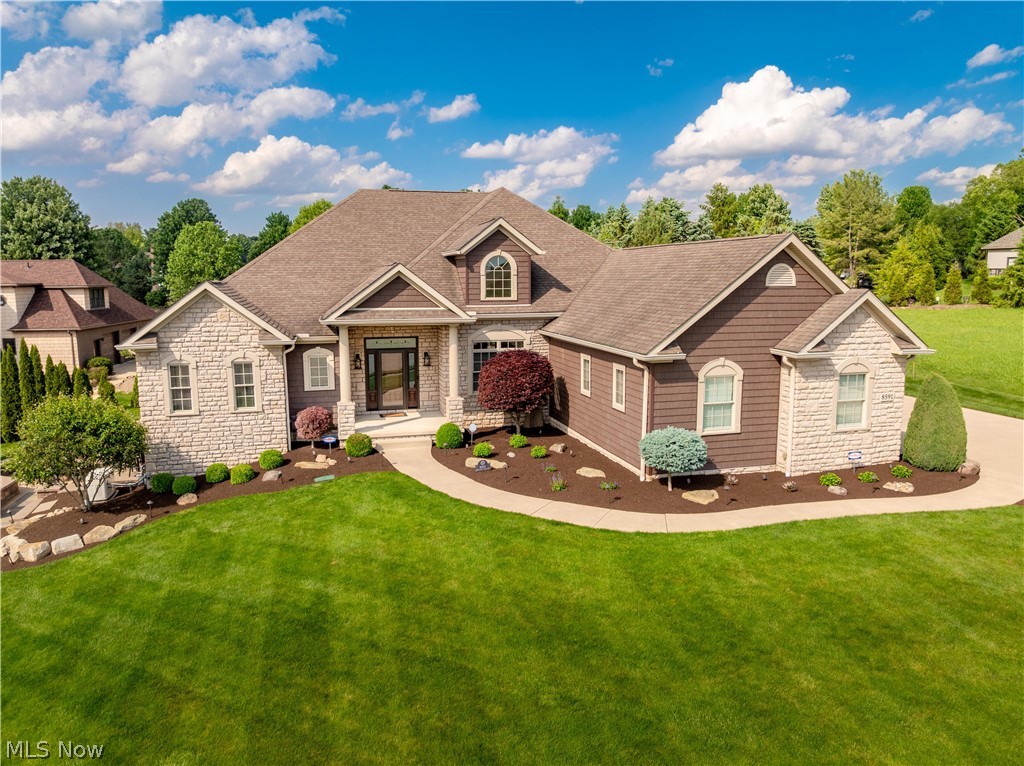 Beautifully maintained and full of character, this spacious 5 bedroom, 5.5 bath split ranch is tucked away on a cul-de-sac in Jackson’s notable Carrington neighborhood! From the moment you arrive, the professionally landscaped lot and exceptional curb appeal showcase the pride of ownership throughout. Inside, you'll find over 5,300 square feet of living space starting at a welcoming foyer with 10-foot ceilings and cherry hardwood flooring that opens into the heart of the home, where hardwood floors continue through the hall, kitchen, dining area and powder room. Abundant windows and transoms fill the home with natural light, highlighting the spacious eat-in kitchen and cozy great room featuring vaulted ceilings, built-ins and a gas fireplace. Relax most of the year in the enclosed 3-season room overlooking the backyard. Quality custom woodwork, crown molding and wainscoting add elegance throughout. The luxurious owner’s suite offers tray ceilings, access to the enclosed porch and a stunning bath with Cambria quartz double vanity, soaking tub, stone accents and an incredible custom tile shower. The main level includes 4 bedrooms, each with access to a bathroom, including one with a convenient Jack-and-Jill layout. The walkout lower level is an entertainer’s dream with a spacious rec/family room, built-ins, wet bar with granite countertops, Sub-Zero refrigerator/freezer, wine rack, dishwasher & newer ProVia French doors leading to a private paver patio with natural gas firepit. A large ensuite bedroom with egress, workout/game room, bonus rooms & ample storage complete the lower level. Major features& updates include brand new Trane central AC, Generac generator, newer siding and gutters, newer garage doors, landscape lighting and irrigation, ProVia fiberglass front door, newer fireplace insert, Cambria countertops, newer kitchen appliances, custom Bali blinds, Ring cameras/doorbell & more. A truly exceptional home offering luxury, space and quality throughout!