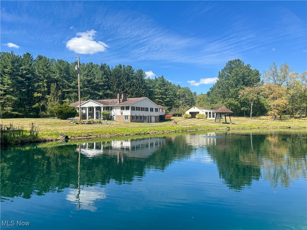 SPRAWLING COUNTRY ESCAPE! This remarkable estate spans three parcels totaling nearly 40 acres, offering unparalleled space, abundant outdoor amenities, and the serene lifestyle you've always imagined. Envisioned for those who crave room to roam, the property features expansive greenspaces, a large pond, a greenhouse, a chicken coop, an outbuilding, and acres of woods for exploring. Inside, the home provides generous living areas designed for both everyday comfort and effortless entertaining. The upper level showcases a welcoming living room with fireplace, a dining room, and a chef-friendly kitchen with a center island and full appliance suite. An oversized family room with a vaulted ceiling, a wood-paneled game room featuring a brick fireplace, and a sunroom overlooking the backyard create ideal spaces for relaxation, recreation, and lively celebrations. The spacious primary suite includes a dressing room, a glamorous bathroom, and an oversized bedroom. Two additional bedrooms and a guest bath complete the upper level. The lower level features a recreation room with a fireplace, a kitchenette, and a half bath, as well as a large bonus room that includes an indoor grill and offers direct access to the outdoor patio overlooking the pond. An additional lower-level kitchen provides ample space for hosting even the largest Fourth of July cookout, with a convenient garage door for easy unloading of party supplies. If you’re seeking abundant space for living, entertaining, and outdoor enjoyment, this property delivers it all!