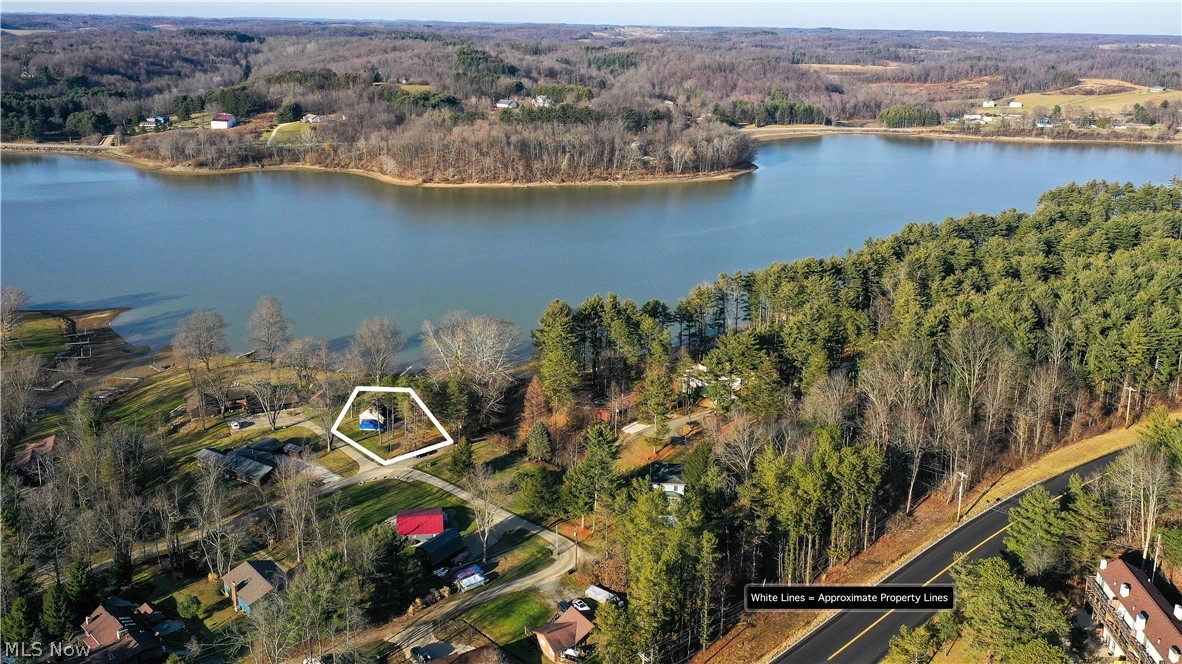 7127 Elgin Dr SW, Sherrodsville Ohio 44675 is a beautiful lake front home w/ gorgeous setting on Southeast side of Atwood Lake of the Muskingum Watershed District. Large parcel of leased land at the end of a dead-end road at start of The Pines has direct access to the lake from the property, as well as its own boat dock w/ 2 boat slips. Awesome home w/ great lake views from both levels has up to 5 bedrooms, 2.5 bathrooms, 3 car garage & plenty of storage. Walk out lower level has stunning views of the lake & includes the Family Room / Recreation Room w/ woodburning fireplace, bar area, full bathroom w/ shower, plus Laundry Room & Utility room w/ workshop. Sliding glass doors open to ground level concrete patio & direct access to the lake. Main floor includes huge living room w/ open concept to the Dining Area & offers calming views of the water from all the windows & opens into the retro, clean & bright kitchen! Wrap around deck on 3 sides allows for extended outdoor living areas to en