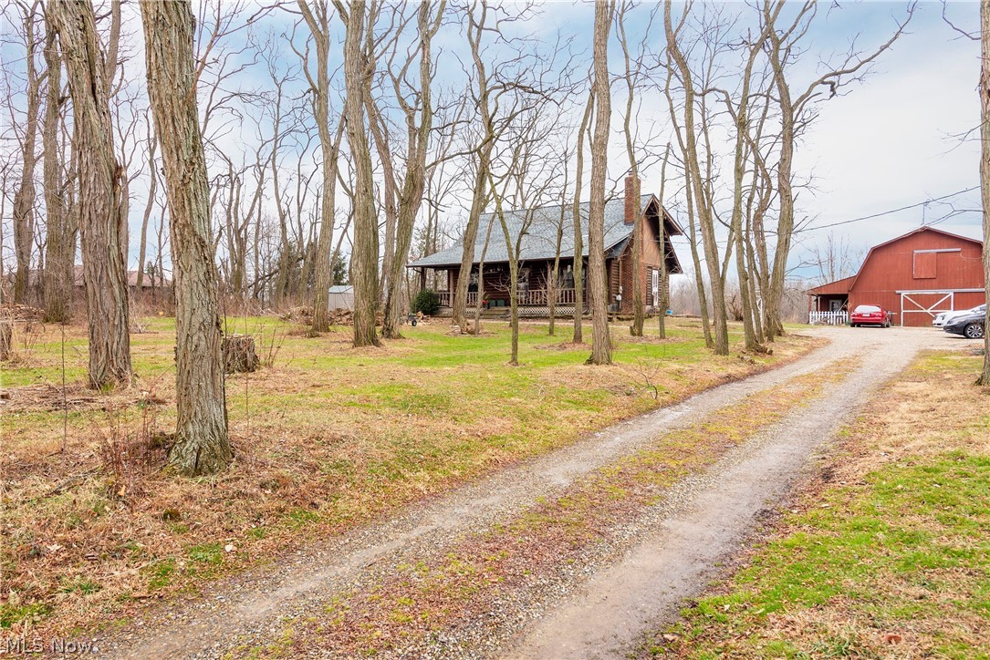 Welcome to the wooded 6 acres and log home of your dreams!   Check out the views as you enter the tree lined driveway to the home.  Boasting a large barn with 3 stalls, workshop and more!  The private lake views are just a small part of the scenic, nature filled location of this one!   The owners have made many updates including an updated kitchen with tile counter tops and floors, breakfast bar area and of course open ceilings!  The living room boasts a full wall chimney with wood burning fireplace, new front door and openness everywhere!  2 bedrooms as well as an updated full bath grace the remainder of the main floor.  As you wander upstairs, your eyes will fall upon the spacious loft area with amazing views of the first floor.   Also adorning the second floor are two additional bedrooms and another updated full bath!   The lower level of the home includes a family room area with wood burning stove, new wood flooring and a 5th bedroom   The unfinished portion offers plenty of storag