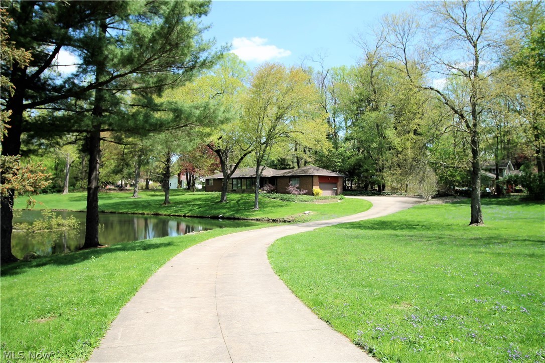 Do you want privacy? Welcome to this charming ranch with winding driveway that sits back from the road and has an astonishing pond to enjoy on over an acre lot. This two bedroom, one and half bath home offers a large bright and airy great room with magnificent large windows to view the sensational pond and also offers  wonderful hardwood floors, built in bookshelf and fireplace. The kitchen has eat in area, abundant of cabinets and counter space and offers an extended stainless steel food prep work area and pantry. The dining room is off of the kitchen with hardwood floors and plenty of windows to let in the sunshine. There are two large bedrooms with large closet space, hardwood floors and nice size windows. The huge finished lower level can offer so much more space for an additional family room, recreation room, office space etc there is also an extra shower. There is a two car attached garage with water available. The back porch is a nice area for grilling and there is a shed as wel