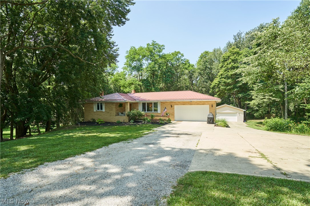 Walk in and say I'm home!! This well maintenance all brick ranch on 2 acres offers the serene and private setting. 
 Living room with electric fireplace, totally remodeled kitchen in 2019 with quartz countertops, and a conventional open view to the sunroom open to the kitchen has French doors, vaulted ceiling, sky lights, bright light view to the sunroom. bright light enters through all the windows, a new sliding glass door access to the wrap around deck. Natural hardwood floors are under the carpeted areas. Entertaining galore in the lower level finished walk out basement that features a pellet stove with a full bathroom, tons of storage an additional kitchen area with a stove and microwave. and access to the screened porch and hot tub to enjoy the private back yard with a fire pit, stamped concrete sidewalk to the additional 2 car detached garage. enjoy a nature or jump on your ATV on the trails in the back treed lot