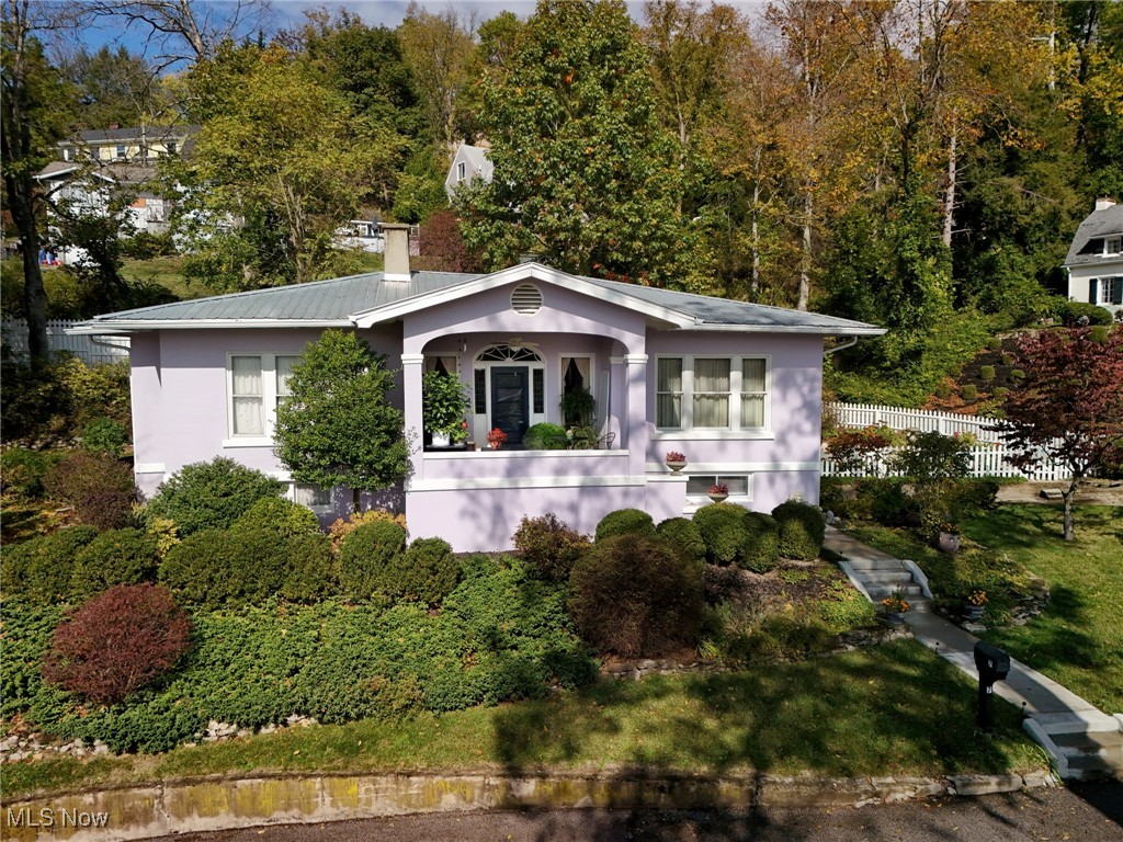 Historic charm meets modern comfort in this one-of-a-kind home. Welcome to 7 Arlington Drive, Wheeling. Presenting a captivating and pristine 3-bedroom residence built in the early 1900s, that seamlessly blends historic character with modern luxury. Nestled with a serene, private setting, this home offers a tranquil retreat while maintaining wonderful curb appeal that will enchant you and your guests. You are welcomed as you enter a large, covered front porch which accents a solid wood door with glass panes which adds an element of handcrafted warmth. You step inside into a spacious central foyer. The wood floors are in pristine condition throughout. Beautiful crown molding and trim traces the ceiling of the dining room. True to the period, the living room features beautifully crafted built-in cabinetry throughout. Large windows throughout which allows natural light. Enjoy the lower level with additional living and much storage. The landscaping that surrounds the entire outside of the home boasts with perennial garden beds, evergreen shrubs and year-round greenery with winding nature stone pathways. May I please welcome you to 7 Arlington Dr.
