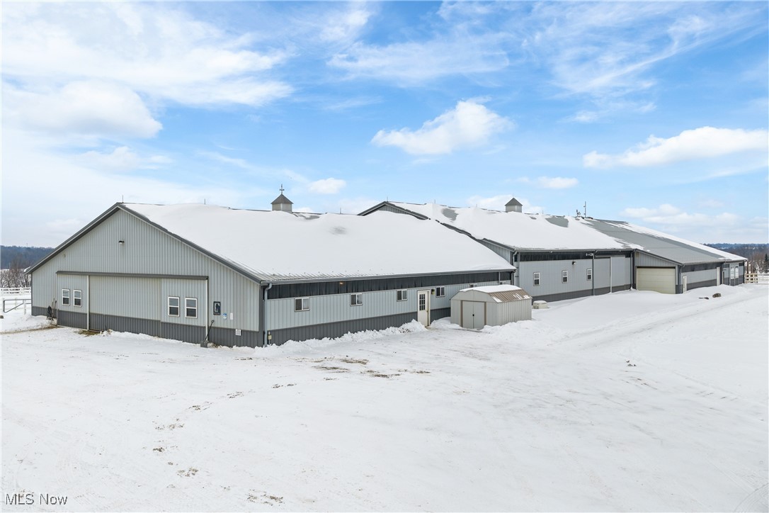 Exceptional opportunity to acquire a premier Northeast Ohio equestrian facility, available as a stand-alone horse property or in combination with the existing residence to create a truly turnkey estate (see MLS# 5173790). The horse facilities may be split into a separate parcel, offering flexibility for owner-operators, trainers, investors, or those seeking income-producing equine assets. This professionally designed horse operation spans nearly 30 acres and features over 21,000 square feet of barn space. The main barn offers 28 indoor stalls with rubber-matted floors and heated automatic waterers, some with dutch doors and individual turnout runs, complemented by 8 additional shedrow stalls, six equipped with electricity and water. There are two heated tack/viewing rooms along with heated grooming and wash stalls. Additionally, a laundry and utility room is present along with a heated restroom. The property is thoughtfully laid out with 15+ safely fenced pastures, all with automatic waterers, plus all-weather dry lots designed for year-round usability and pasture management. Riding and training amenities are outstanding, including a 70’ x 140’ heated indoor riding arena, an expansive 100’ x 300’ outdoor arena, and a professionally designed mountain trail course—ideal for conditioning, training, or unique boarding offerings. Supporting infrastructure includes a dedicated manure management area, clean sawdust storage, and space to store over 2,400 bales of hay, along with 10+ acres of excelent producing  timothy/alfalfa hay fields. Additional improvements include a 1-bedroom / 1-bath apartment, workshop space, RV parking with hookup, and excellent access throughout the facility. Designed for efficiency, safety, and scalability, this is a rare opportunity to purchase a high-capacity, well-planned equestrian operation—either independently or as part of a complete horse farm estate.