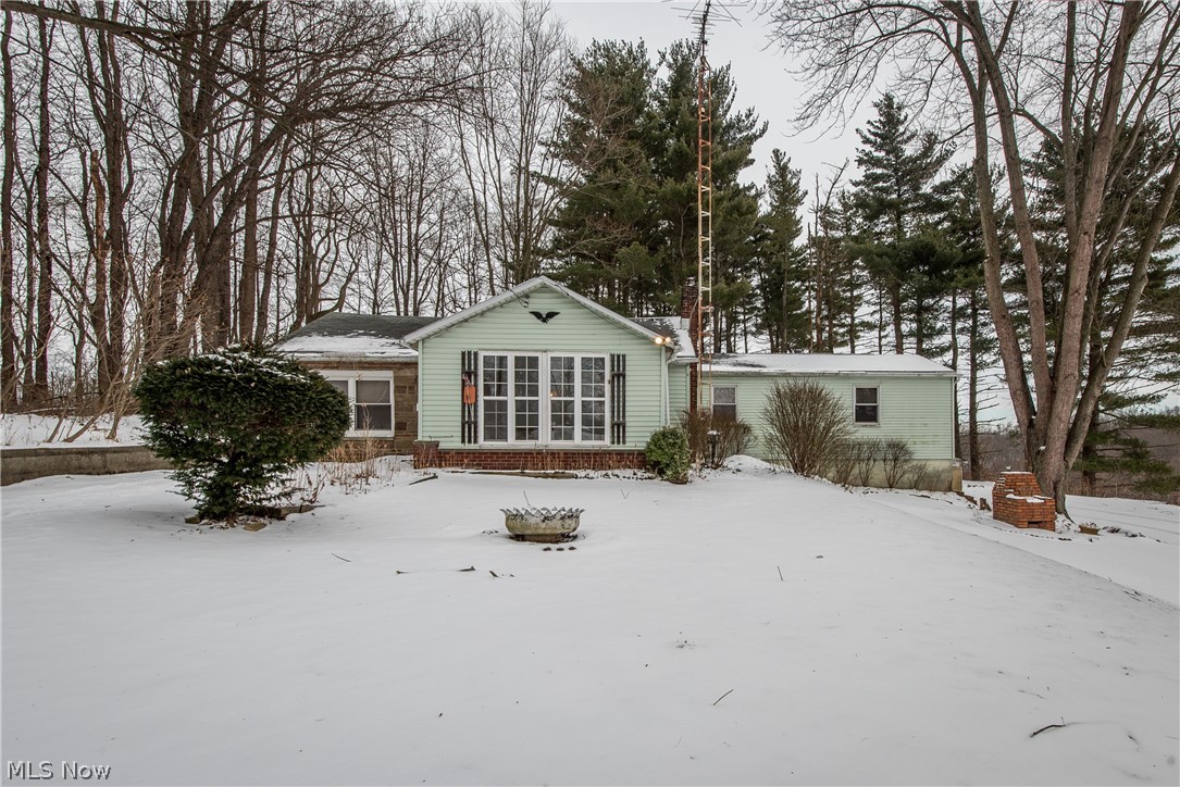 RANCH ON 4.5 WOODED ACRES!  Surrounded by trees and privacy, there is plenty of potential for the savvy investor to turn this into a dream home.  A sunroom entrance opens into the foyer with enough space for a home office.  The spacious living room offers an open view into the dining room.  The kitchen has room for a dinette, plenty of cabinets, appliances, and door to the backyard.  Bedroom 1 has a sliding door to the patio while the 2nd bedroom includes a large private sitting area. The home had three bedrooms at one time but was opened up to make one larger bedroom. The full basement adds room for storage and access to the garage.  If you're looking for a home in need of some TLC but offers seclusion and country views, this is it! Check out the pictures from this past fall. What a beautiful setting.